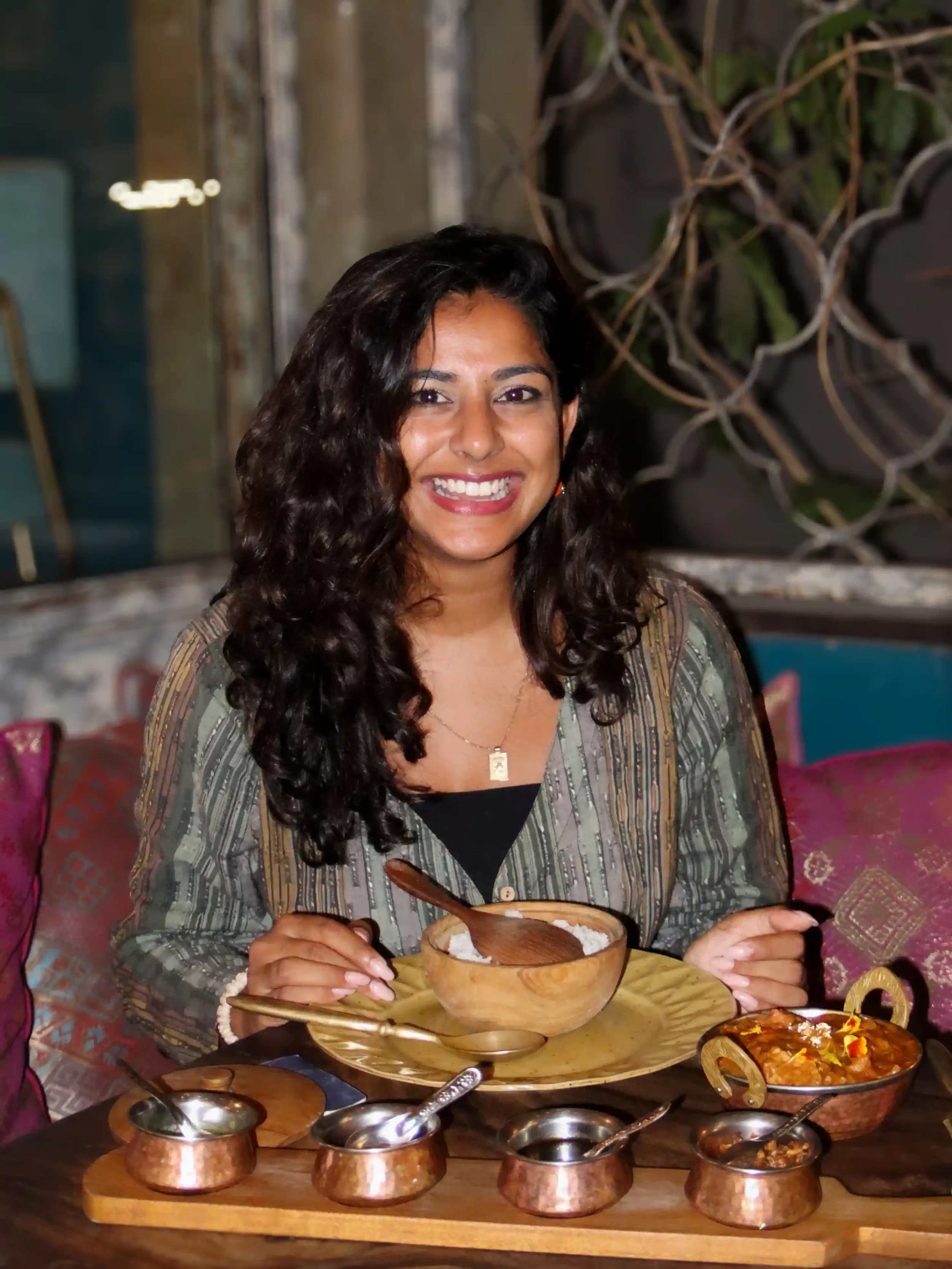 Smiling guest dining on authentic Indian cuisine at Pesona Lounge in Ubud.