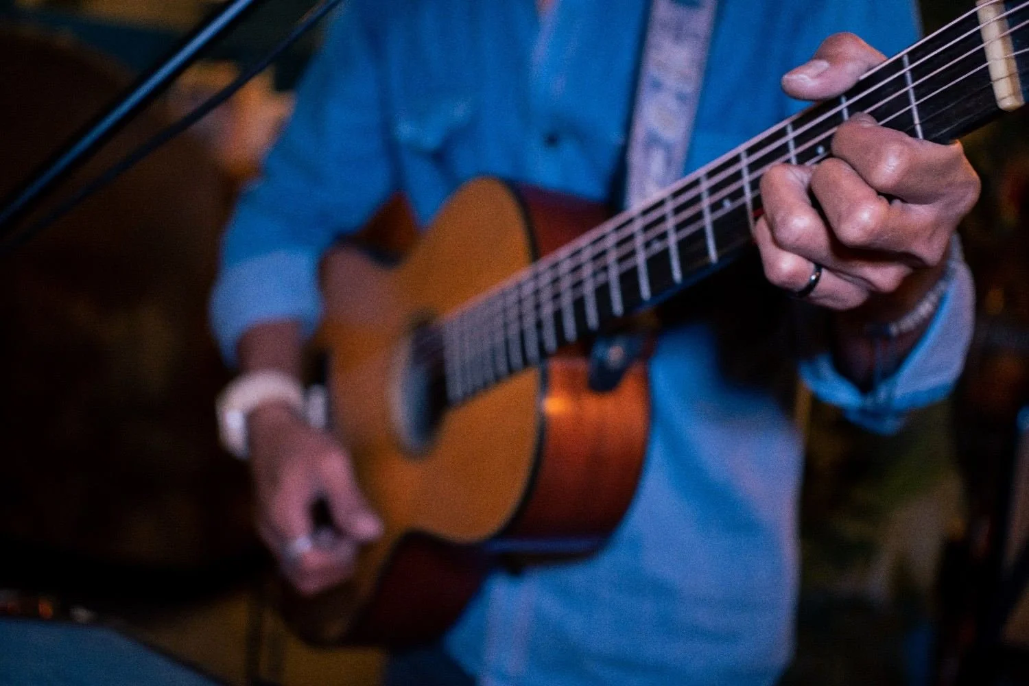 Close-up of an acoustic guitarist performing live music at Pesona Lounge Ubud
