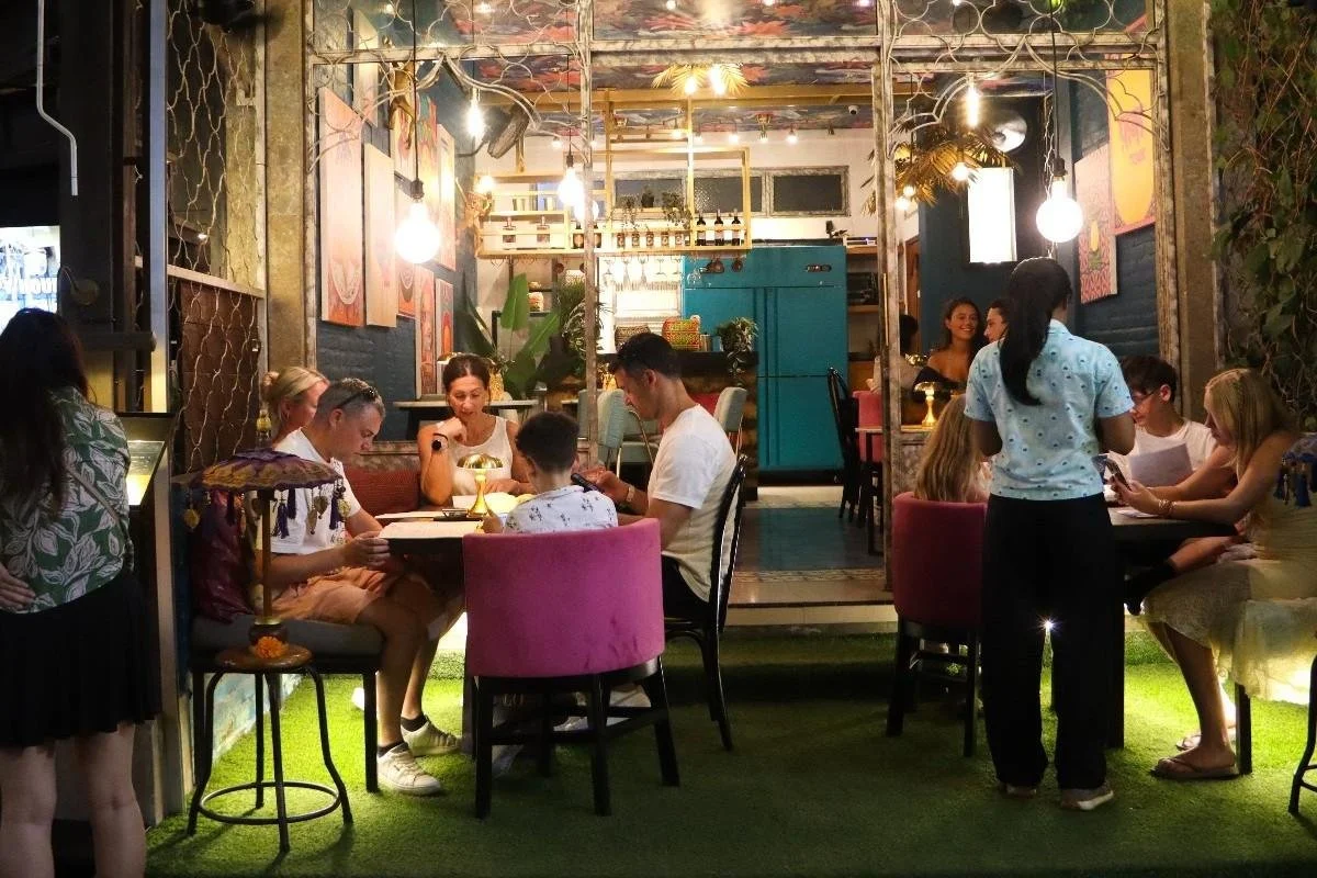 Guests dining in the outdoor seating area at Pesona Lounge in Ubud during the evening.