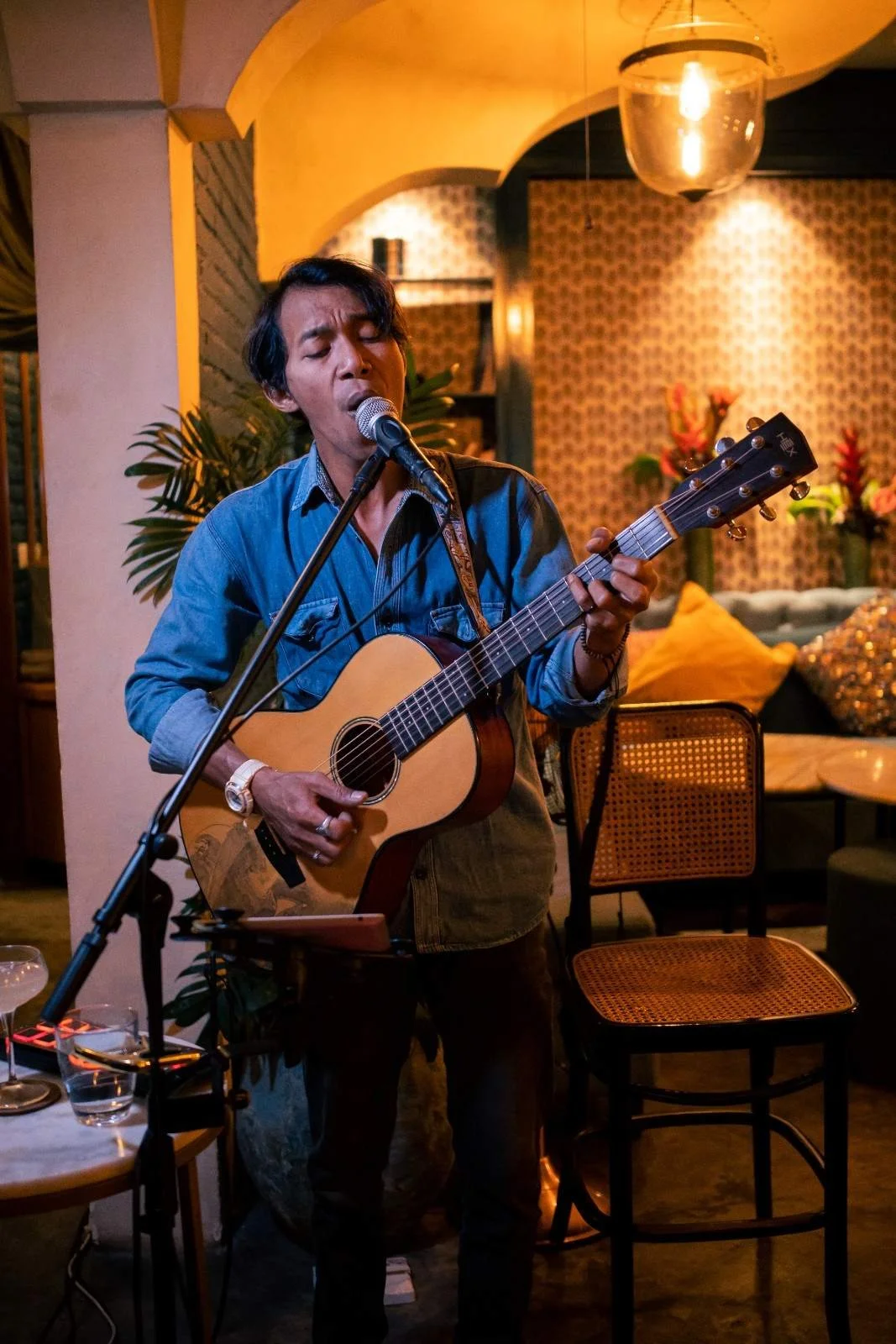 Live acoustic musician playing guitar at Pesona Lounge Ubud during an evening performance