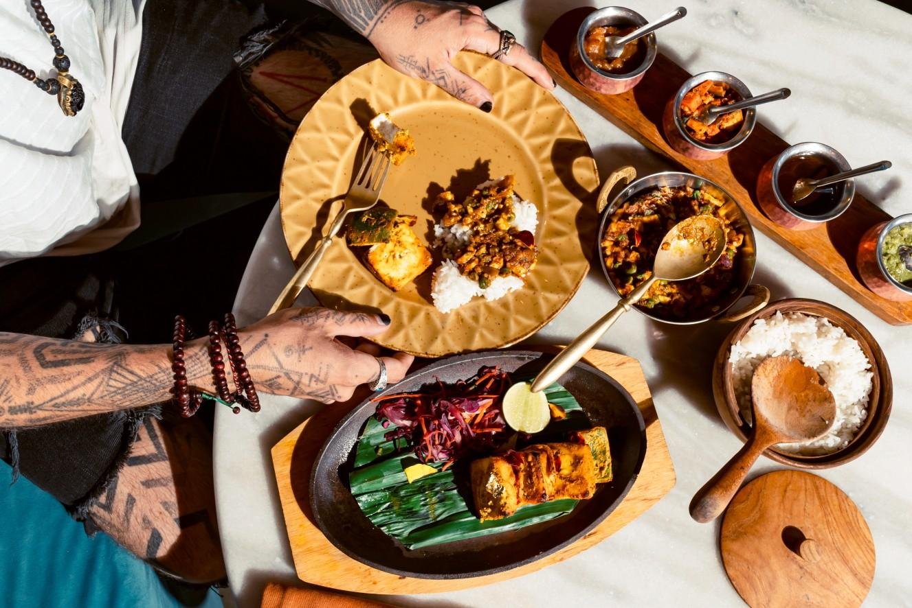 People enjoying a table filled with Indian dishes at a restaurant in Ubud.