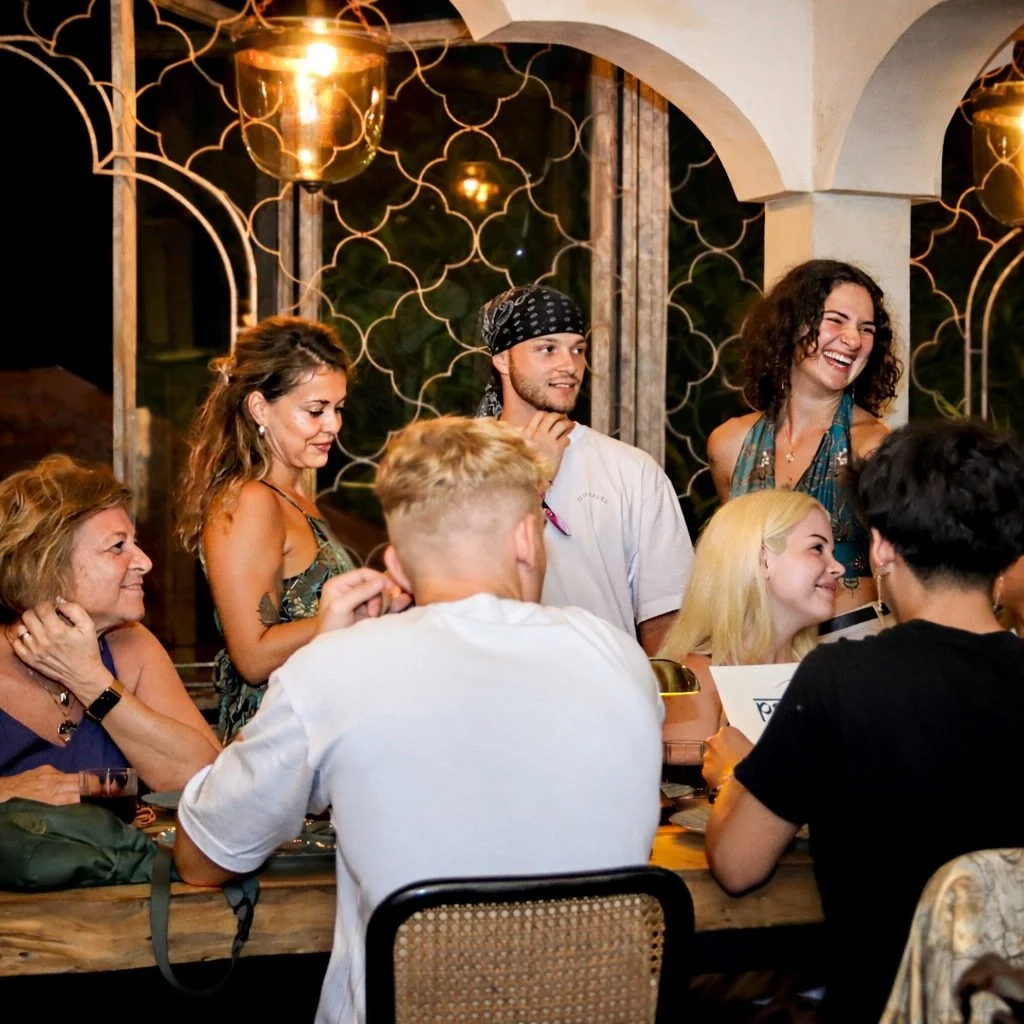 Friends sharing a meal at a lively restaurant in Ubud during the evening