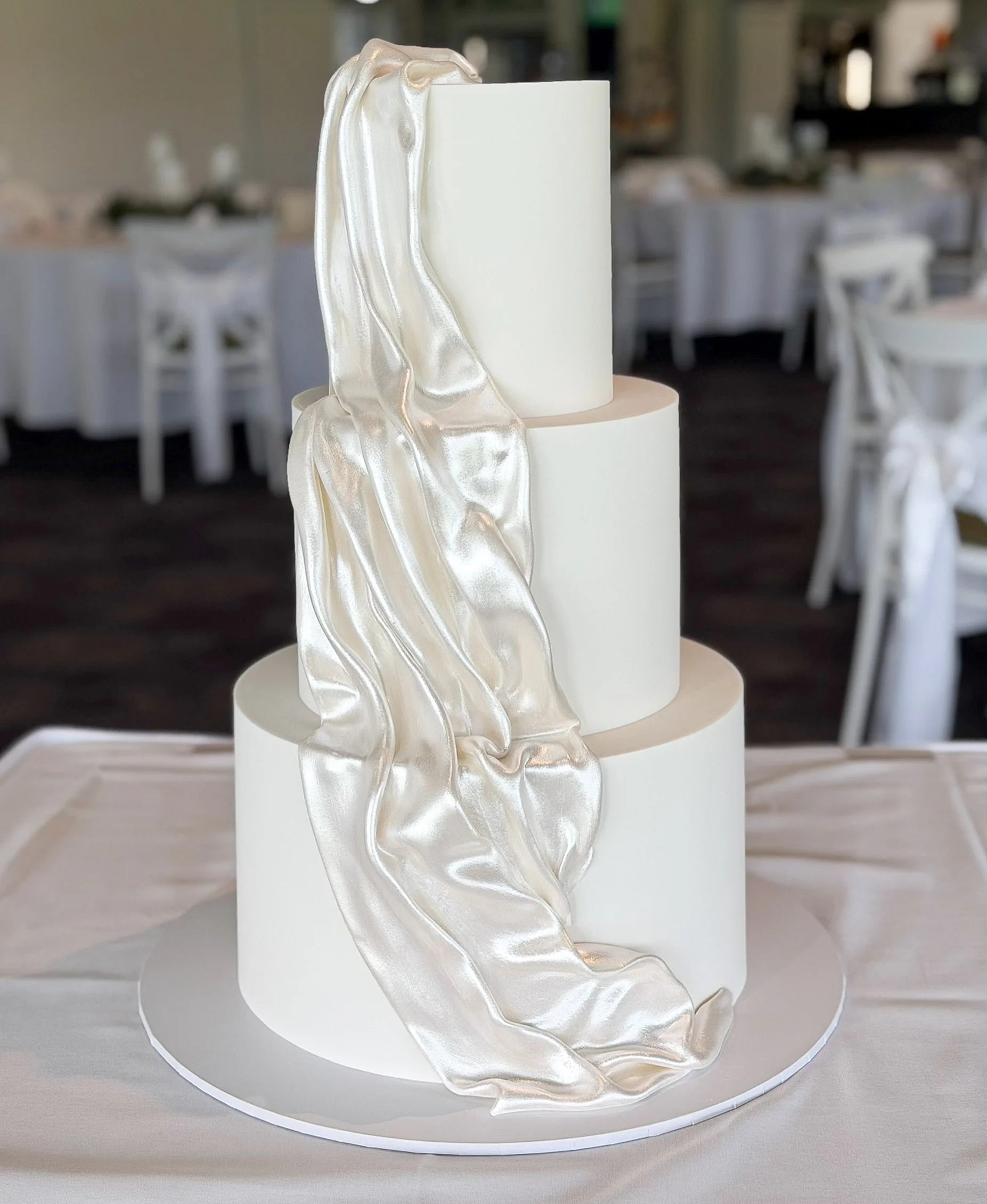 The lustred drape. 🤍 When I showed a sneak peek of this one I received so many messages about it! 
But what do you prefer - matte white or lustred?? 
.
#frostedindulgence #brisbaneweddingcakes #brisbanecakes #weddingcake drapeweddingcake