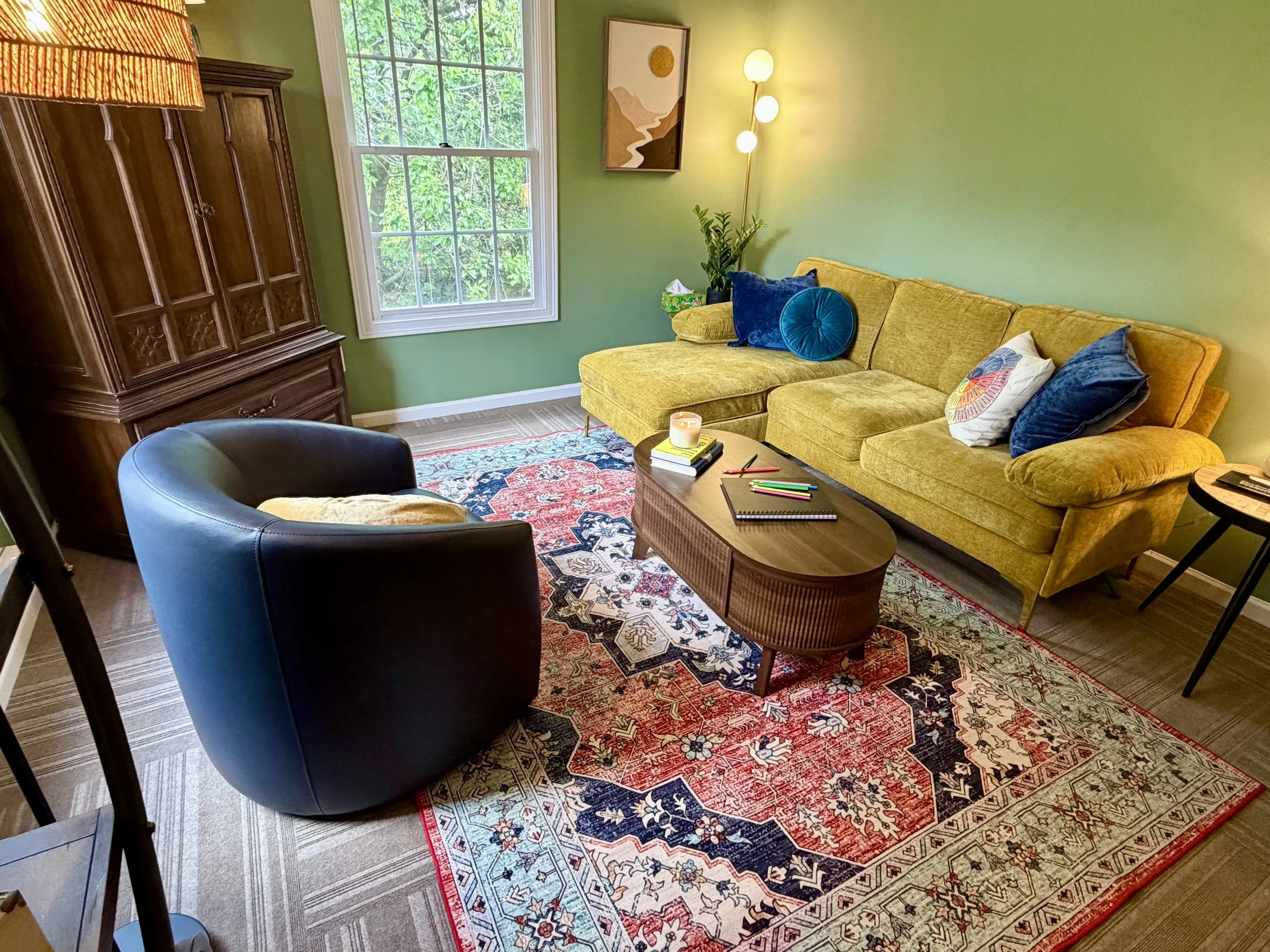 A comfortable therapist's office in jewel tones and natural wood.