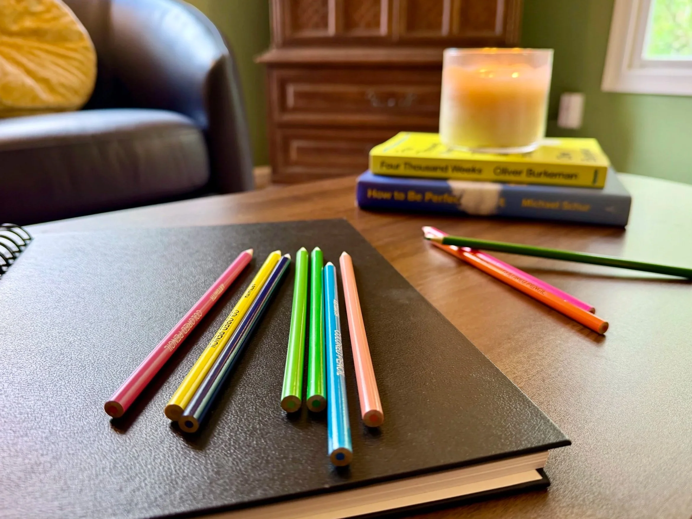 A cozy therapy office with a yellow velvet couch and art therapy supplies