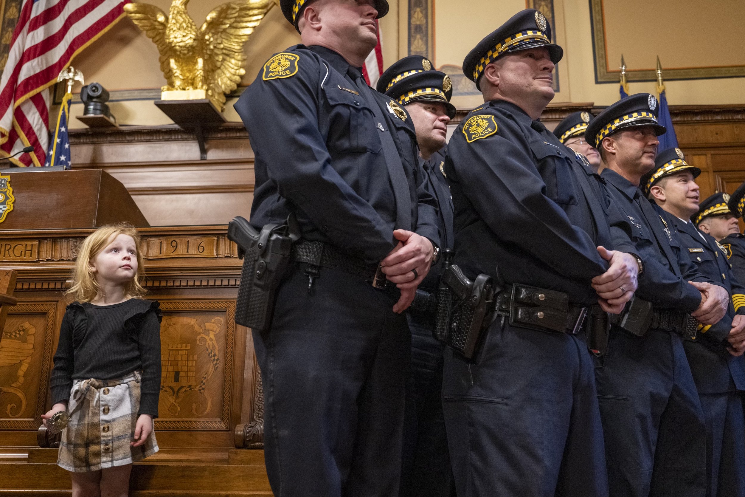  Elle Fleske, 5, left, stands to the side of Policemen and women as they take a group photo after being promoted in rank inside the Council Chambers at the City-County Building on Friday, Feb. 9, 2024, Downtown. Elle’s Father, William Fleske, was pro