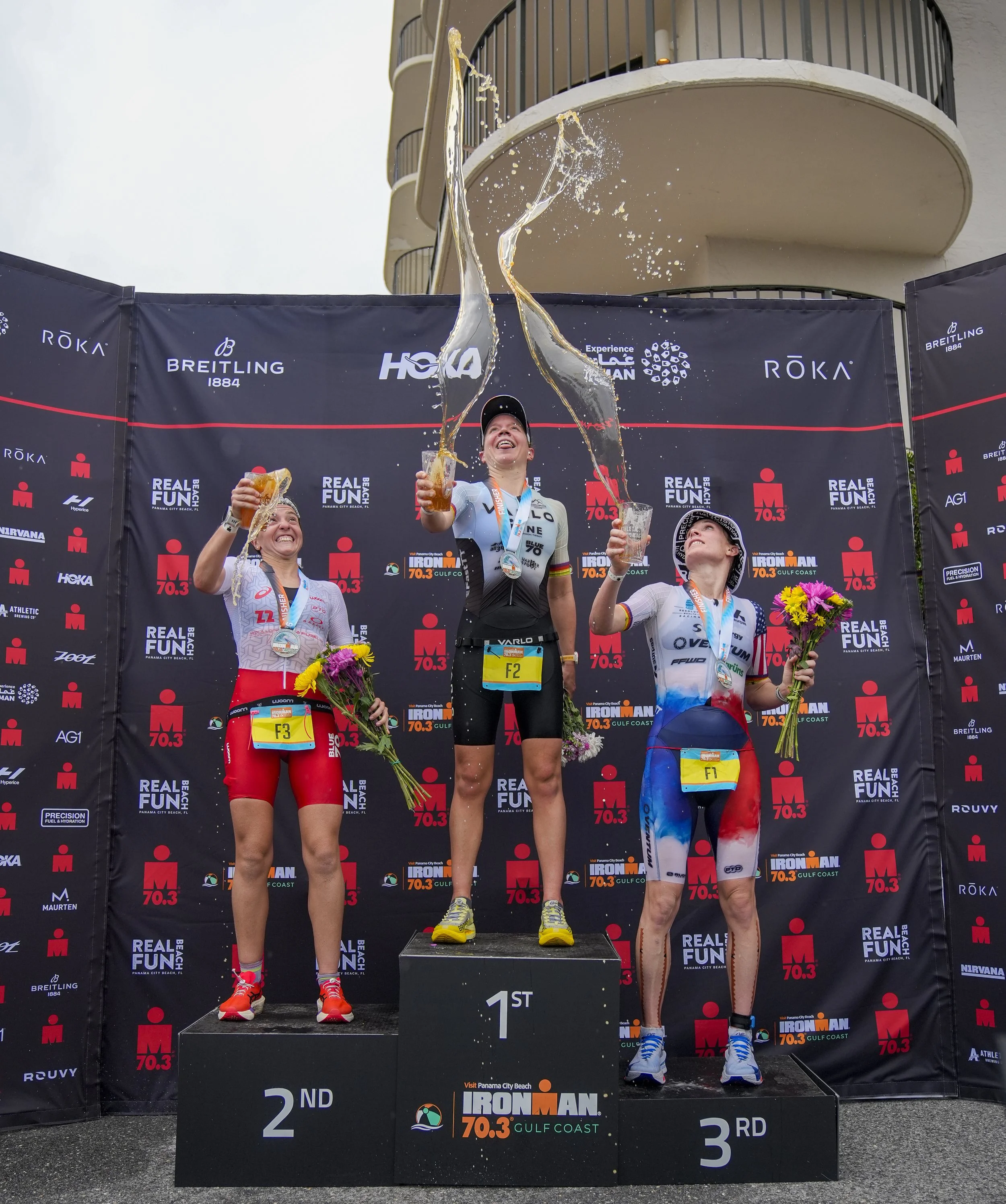  Vittoria Lopes (BRZ), left, Grace Alexander (USA), middle, and Danielle Lewis (USA), stand together on the podium after completing in the Female Pro 2026 IRONMAN 70.3 Gulf Coast on May 9, 2026, in Panama City Beach, Florida. (Photo by Benjamin B. Br