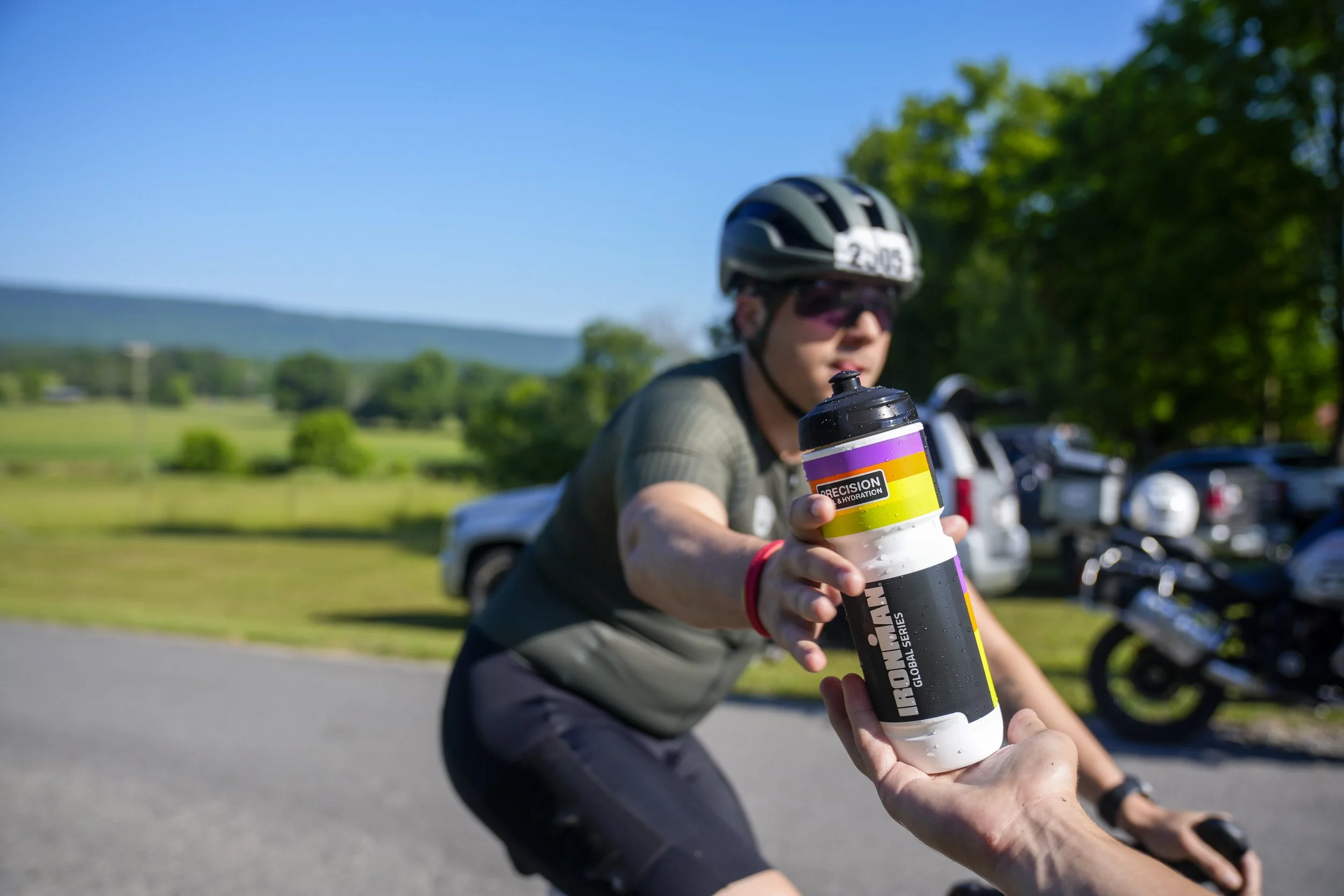 An age-group athlete gets a bottle of fluid at an aid station while racing the bike course of IRONMAN 70.3 Chattanooga on May 17, 2026 in Chattanooga, Tennessee. (Photo by Benjamin B. Braun/Getty Images for IRONMAN) 