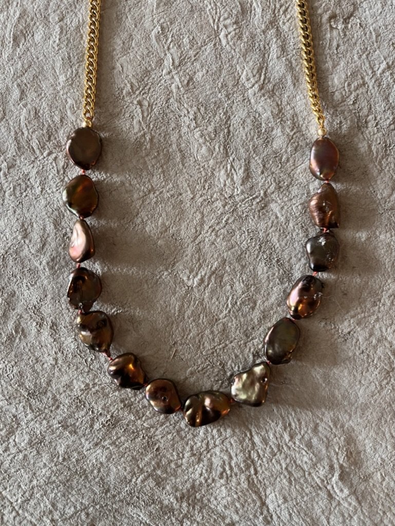 These large, richly colored freshwater pearls are hand knotted and combined with a classic gold tone chain. An elegant piece that layers well with other pieces and stands alone beautifully.
