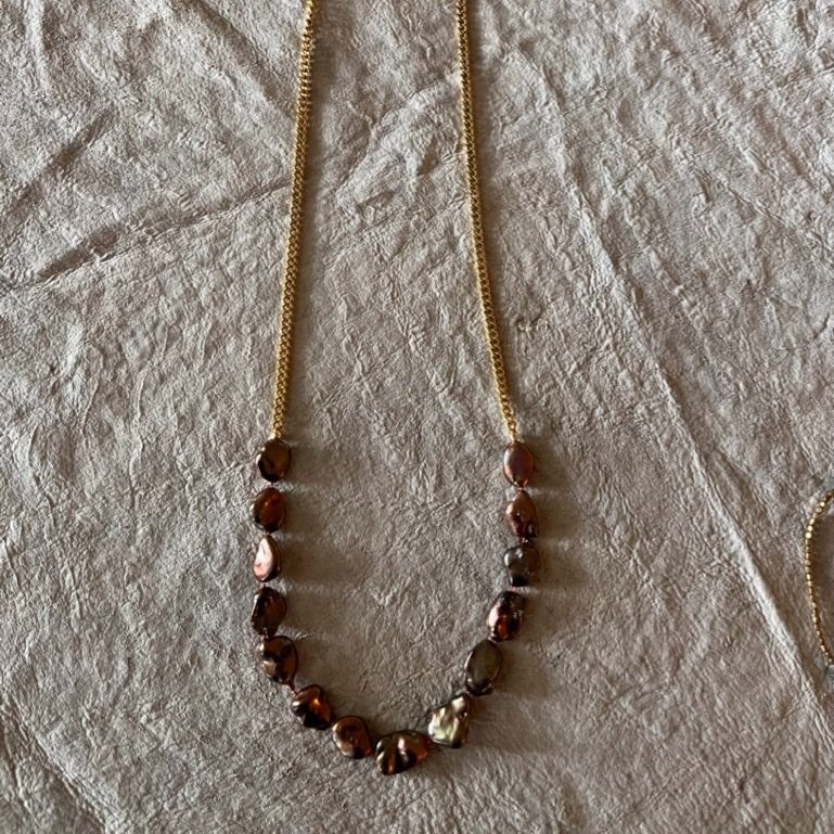 These large, richly colored freshwater pearls are hand knotted and combined with a classic gold tone chain. An elegant piece that layers well with other pieces and stands alone beautifully.