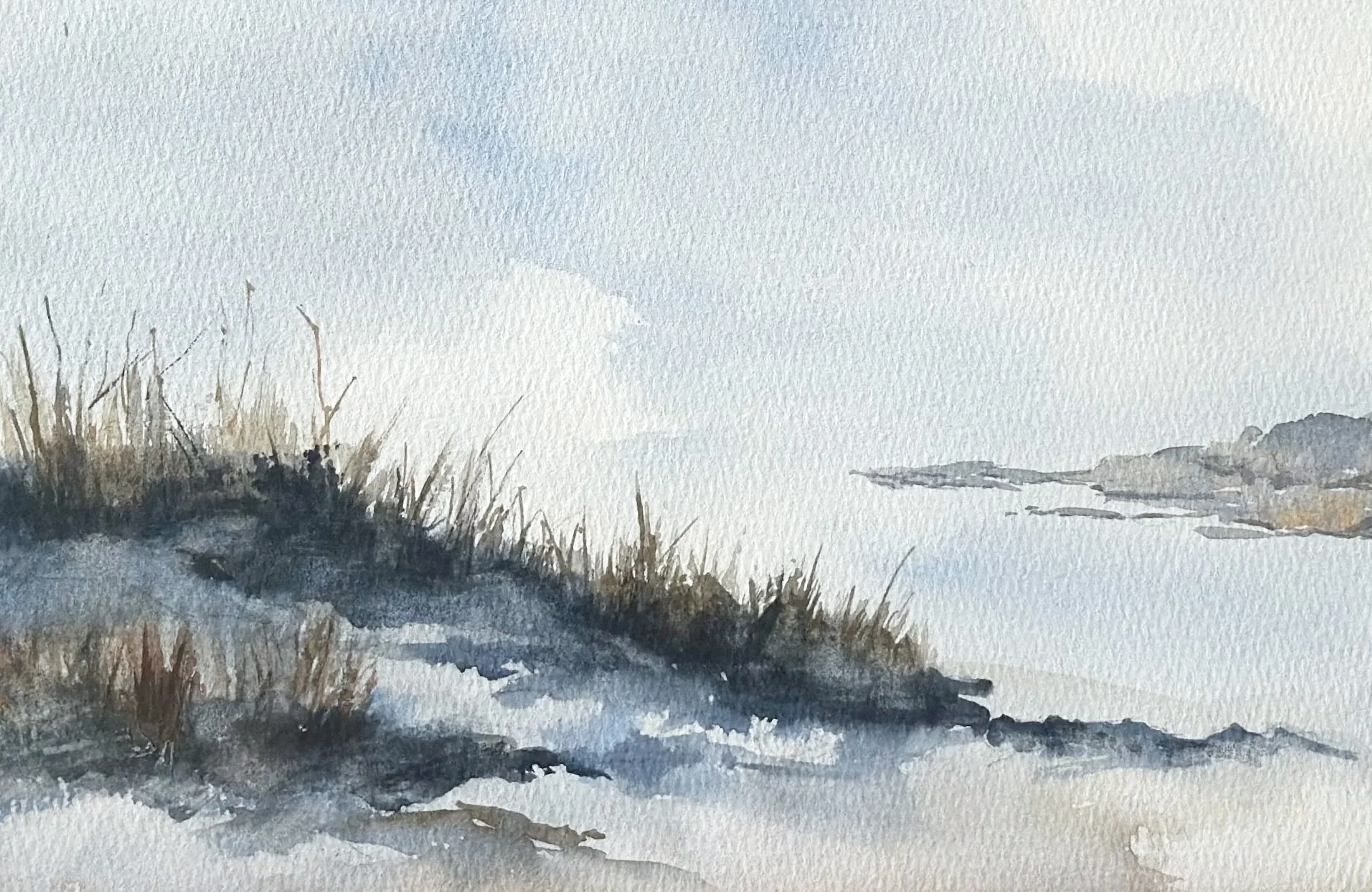 A watercolor painting of a winter landscape with snow-covered ground, dried grass, and leafless bushes in the foreground, a frozen or snow-covered body of water, and distant hills or mountains under a pale sky.
