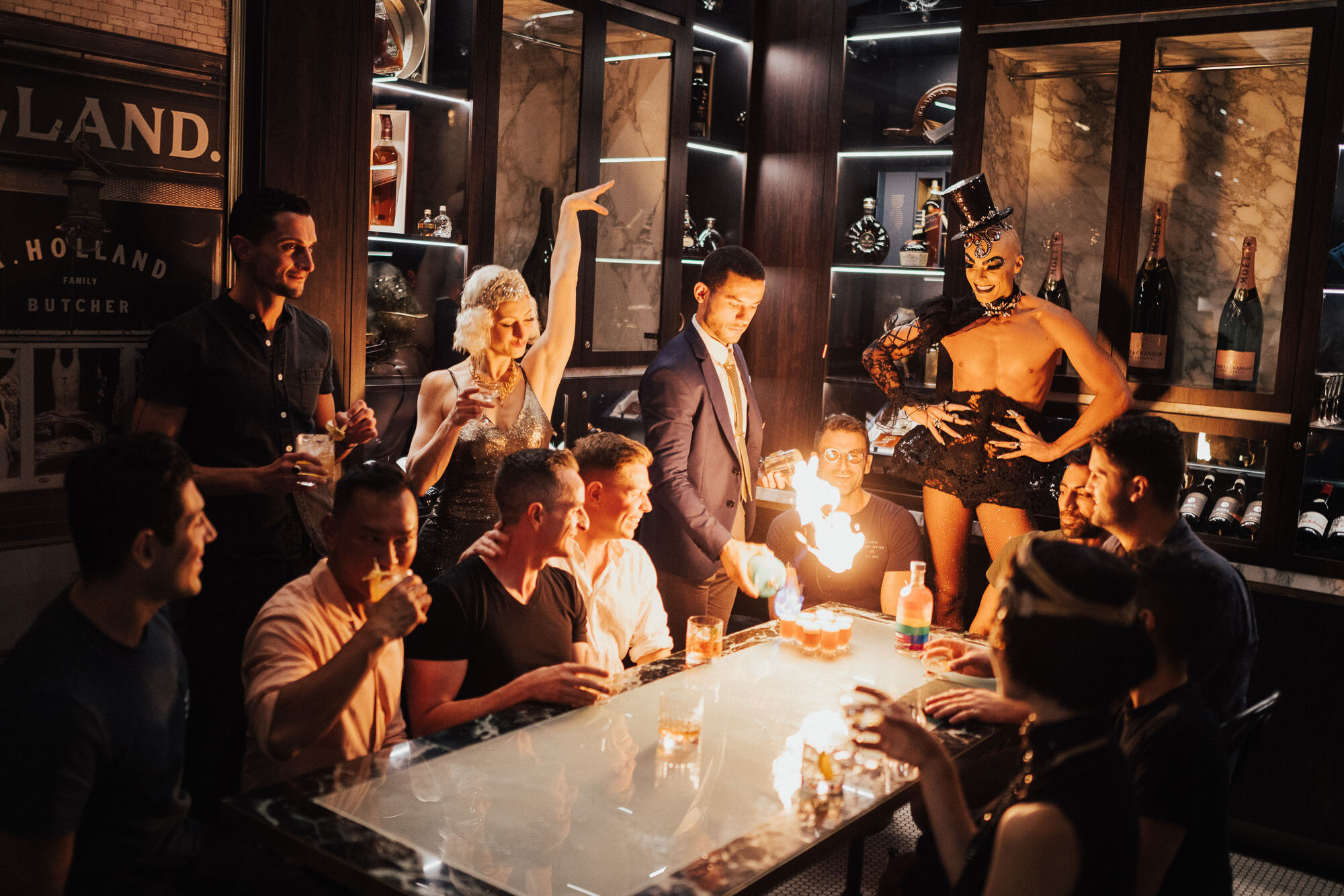 Photo of a birthday party with burlesque dancers and people celebrating with shots