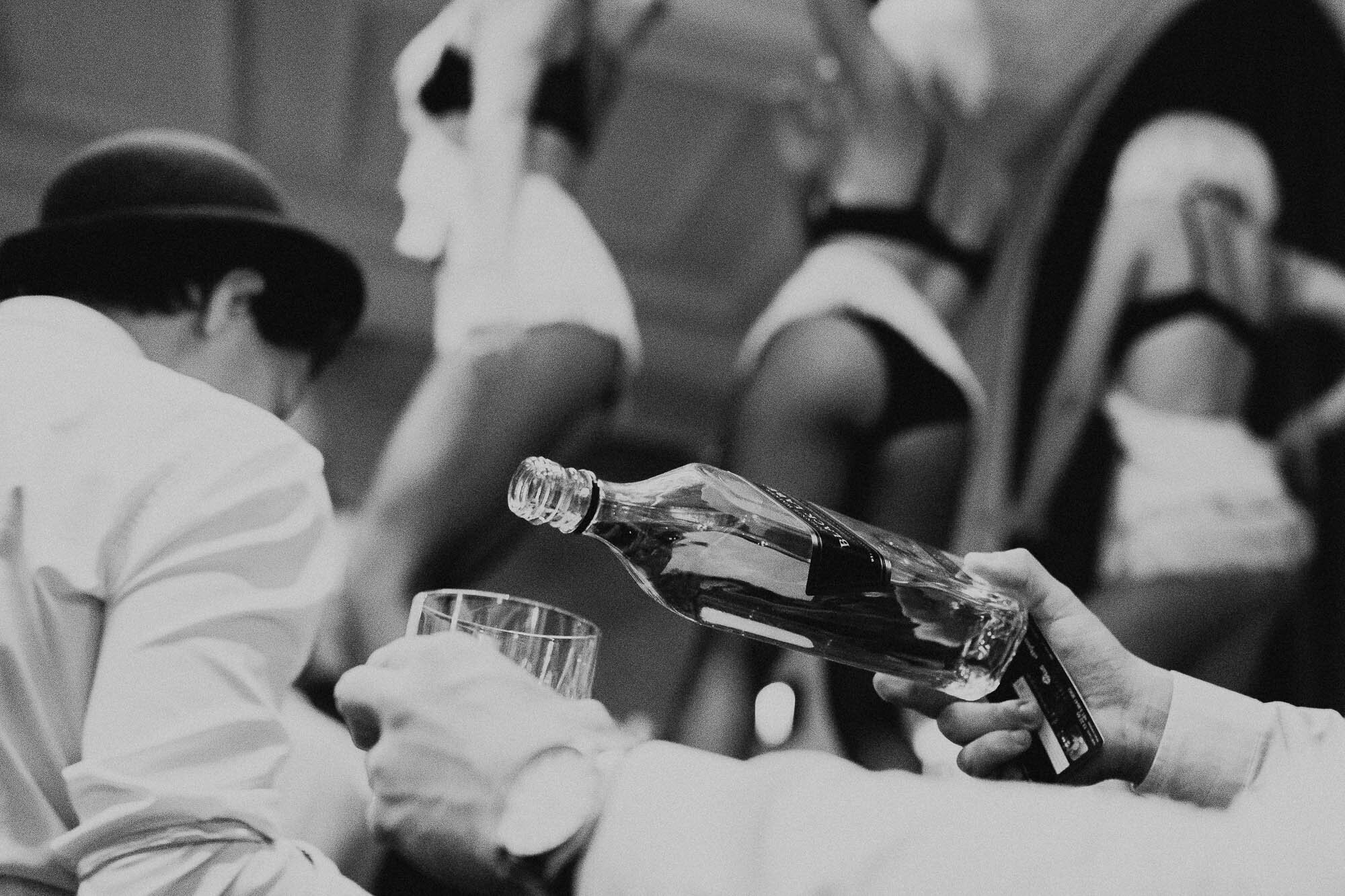 Scotch being poured by a bar tender into on old fashioned glass