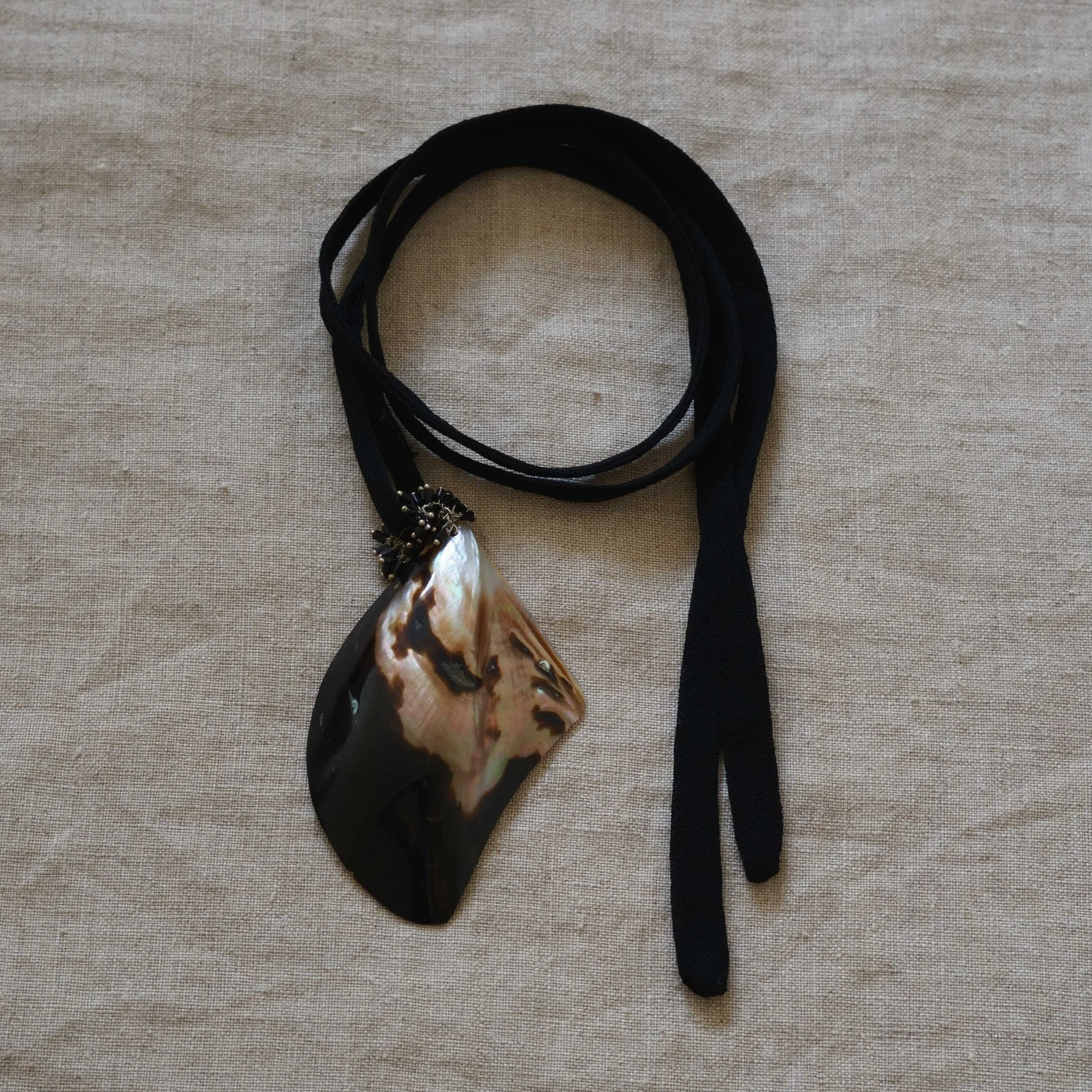 Mussel shell pendants on black fabric