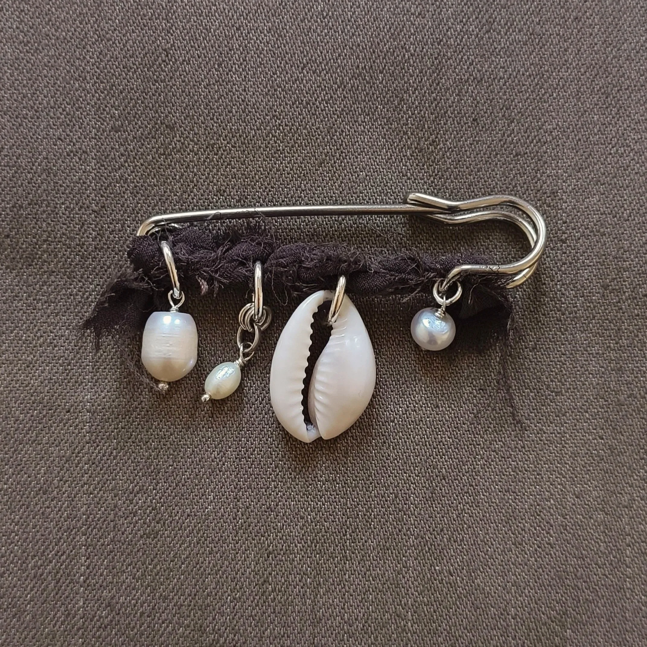 Small kilt pin with trinkets and silk