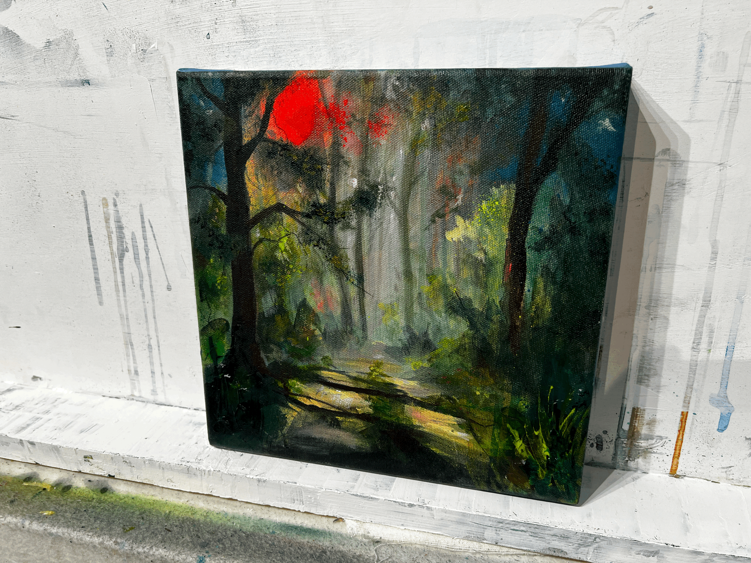 small painting of a forest on canvas sitting on a ledge in my studio