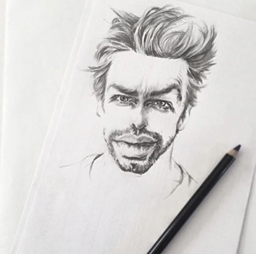 A graphite pencil sketch of a man's face with detailed hair, eyes, and facial features on white paper.
