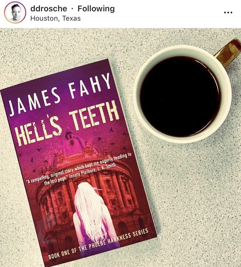 A book titled 'Hell's Teeth' by James Fahy is on a light-colored countertop, next to a cup of black coffee. The book has a purple and pink cover featuring a woman with long white hair standing in front of a large historic building. The setting appear