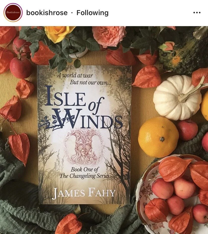 Book cover of 'Isle of Winds' by James Fahy, surrounded by autumnal decorations including apples, pumpkins, and flowers.