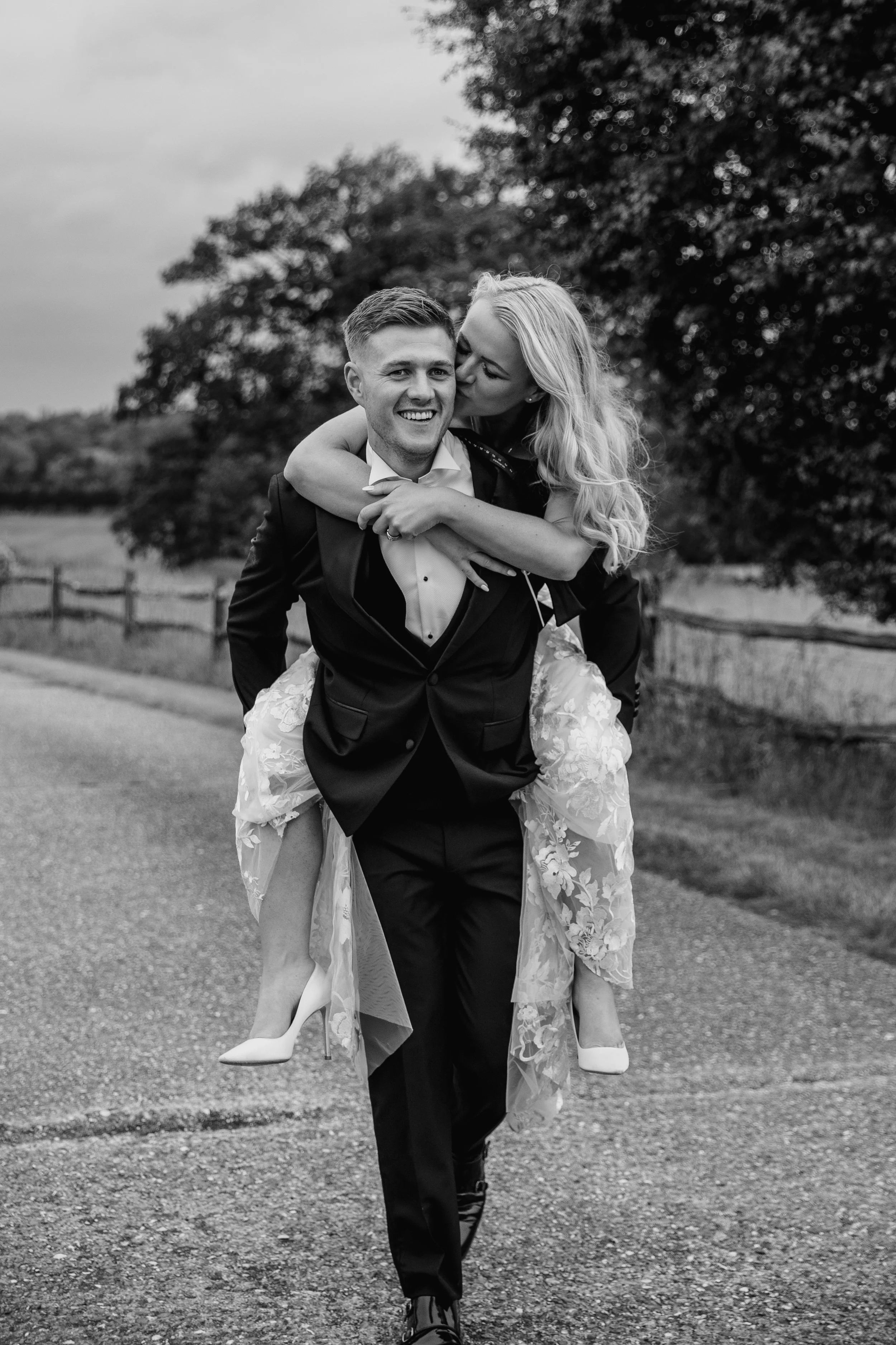 Romantic Portrait of Groom Carrying Bride on his back at Gaynes Park by Essex Wedding Photographer Liam Gillan