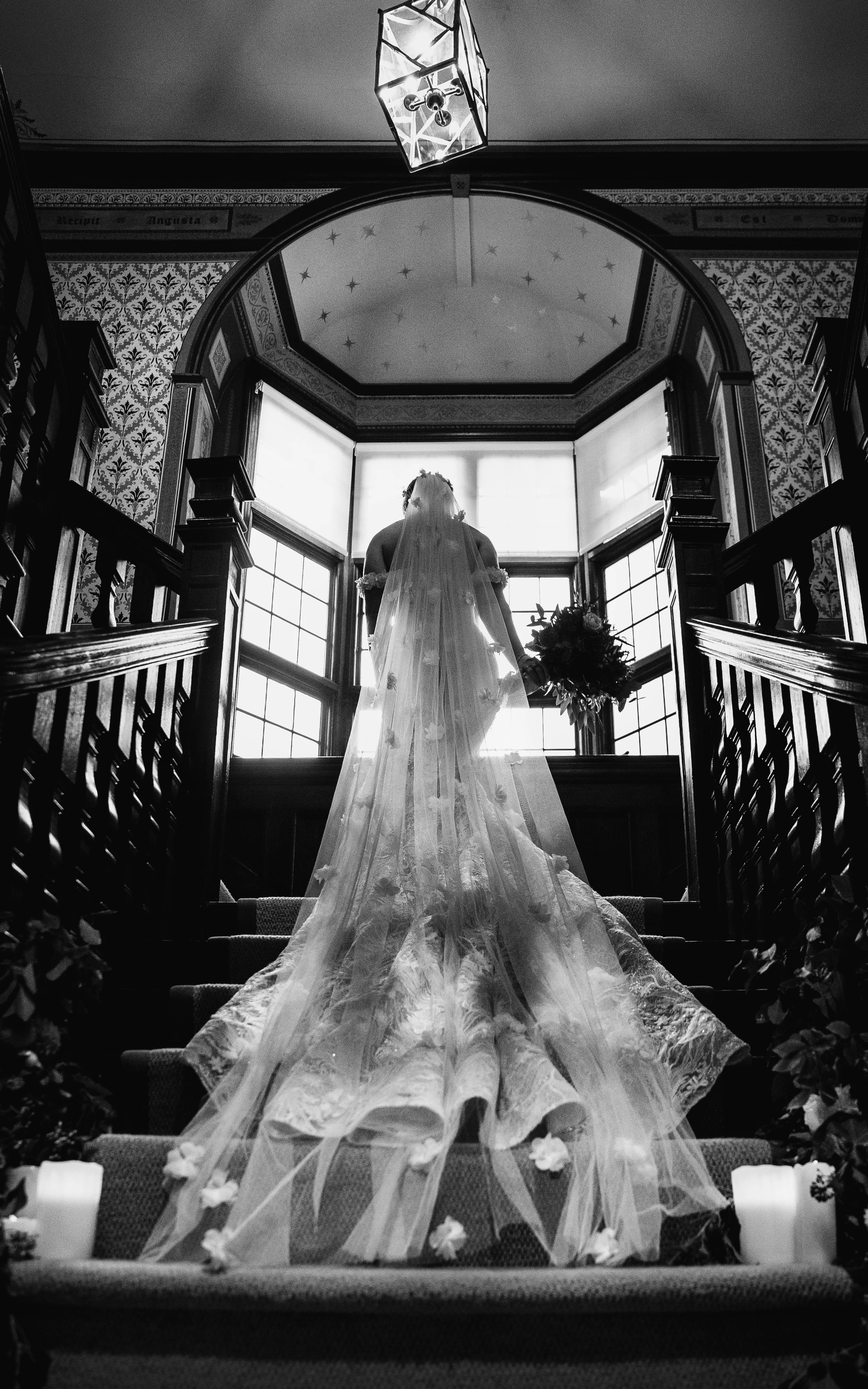 Romantic Black and White Portrait of bride walking up the stairs captured at Baddow Park House, Wedding Photography by Essex Wedding Photographer liam Gillan