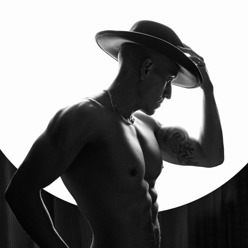 Silhouette of a shirtless man wearing a hat