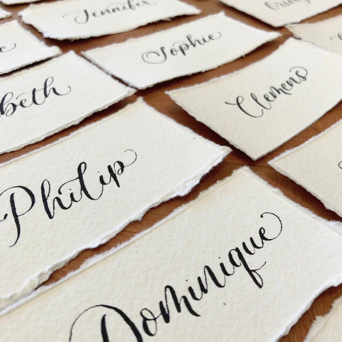 Calligraphy wedding place names with handmade paper and torn edges, black ink on white