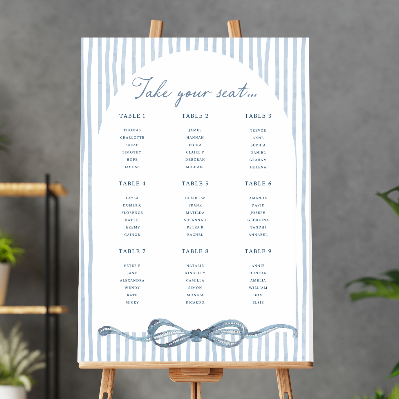 Event seating chart with the title 'Take your seat...' and numbered tables from 1 to 9, listing guest names in a column format on a white background with blue striped borders and a decorative blue bow at the bottom.