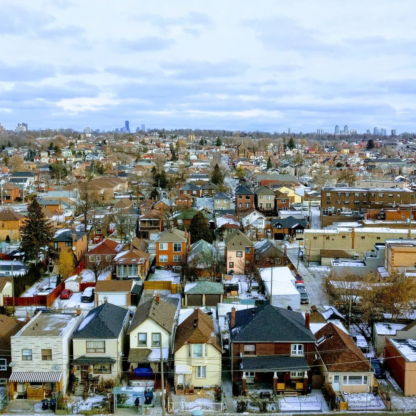 A view of the west side of #toronto last winter shows a variety of housing types in a residential neighborhood. The main road on the right side of the photo is lined with shops. This is a traditional neighborhood layout for a canadian city. 

#toront