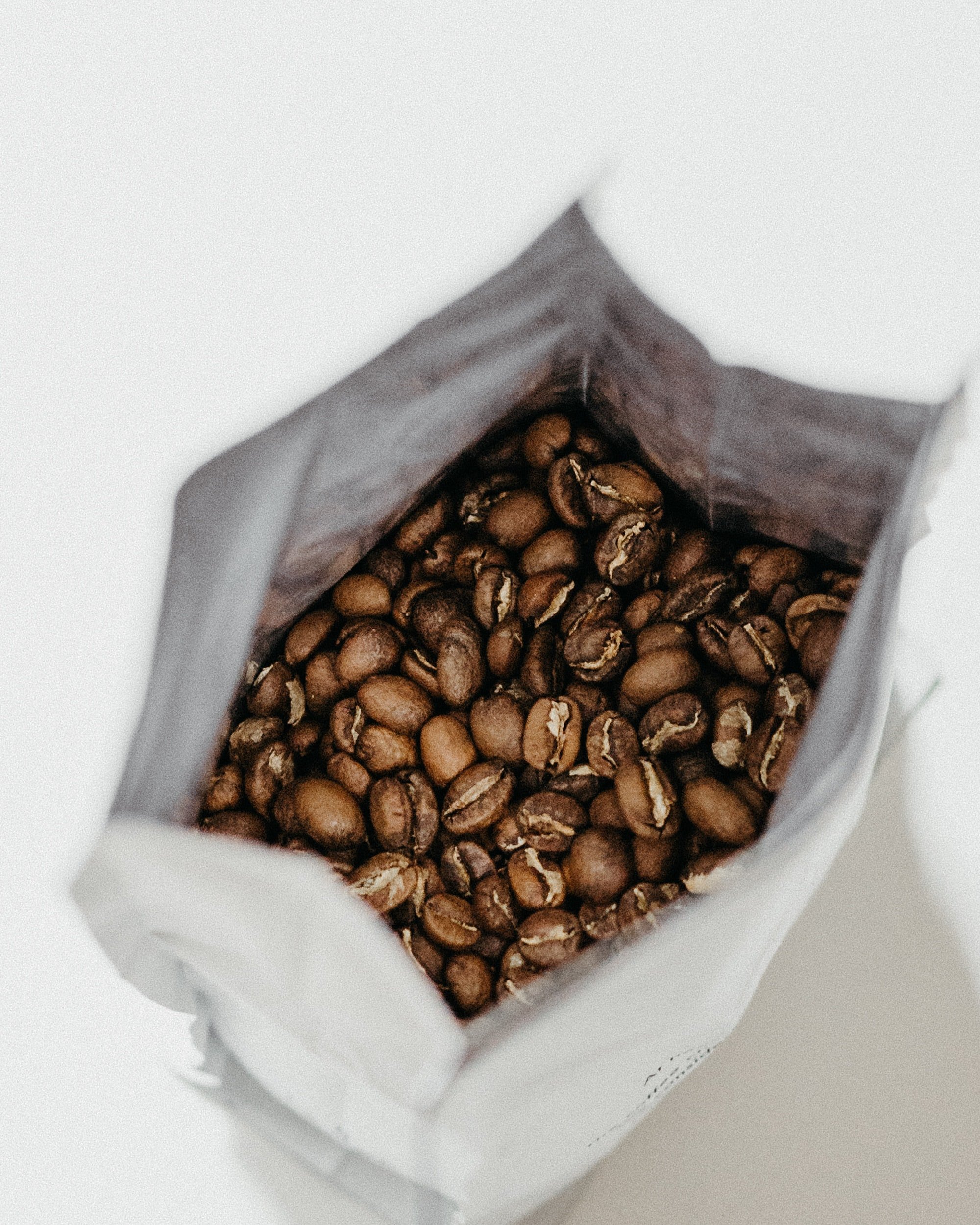 top down view of an open bag of whole coffee beans