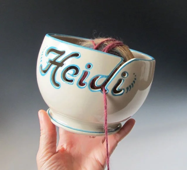 A yarn bowl with a cutout of the name Heidi