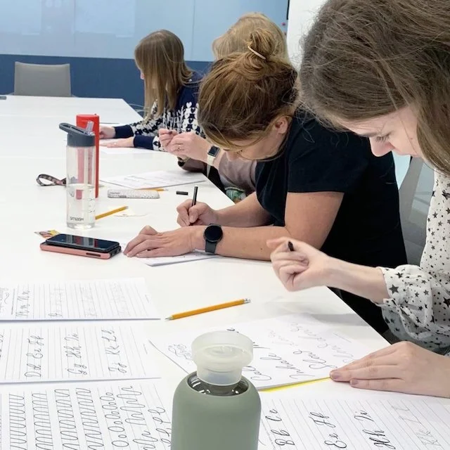 Corporate team calligraphy workshop promoting mindfulness and wellbeing.