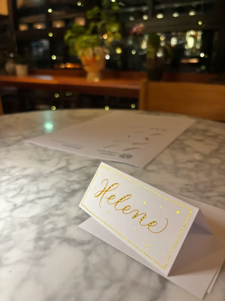 Yellow ochre with sparkly gold calligraphy place card in an evening party setting