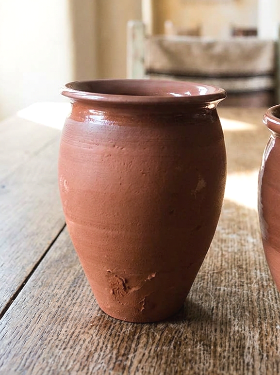 Set of traditional Mexican clay cantarito cups lined up together, ideal for serving cocktails to a group