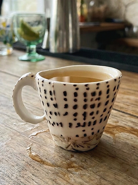 Natural seashell shot cup used as a coastal-themed drinkware on a wooden table