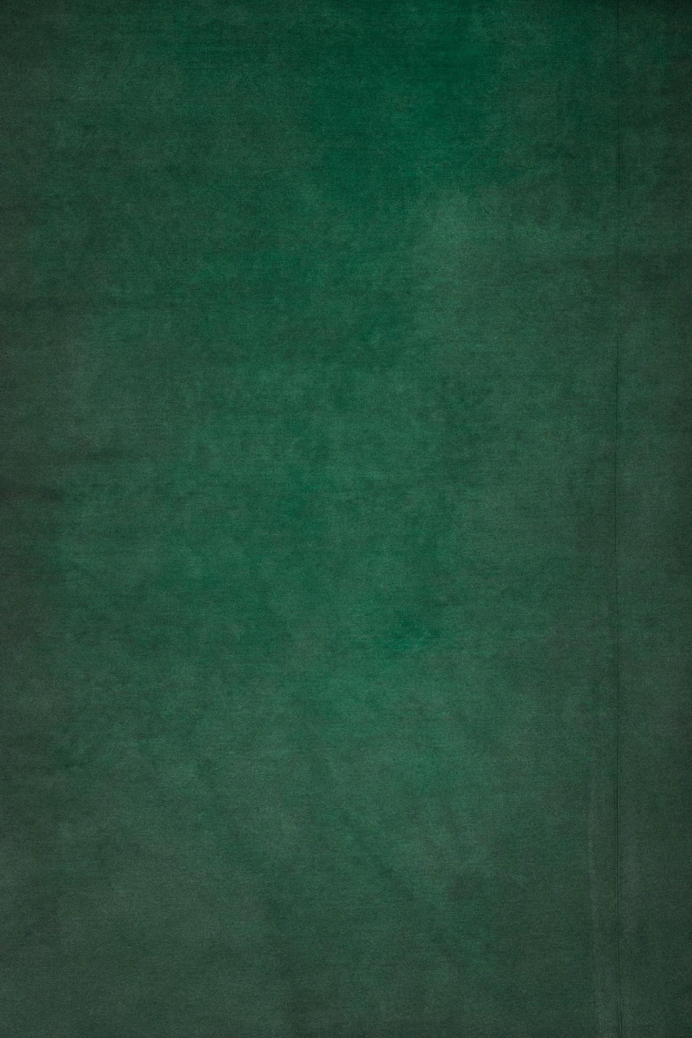 A plain sheet of green paper or fabric, with a smooth and matte texture.