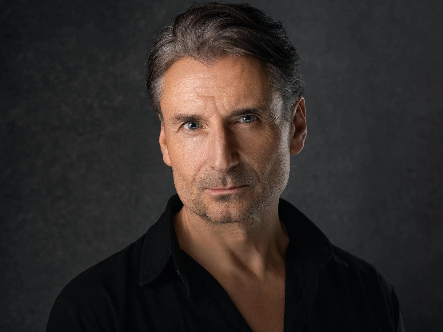 That soft directional lighting coming from the left is sculpting his face with beautiful Rembrandt-style shadows that add depth and dimension without turning this into some moody film noir situation - watch how it reveals skin texture and facial cont