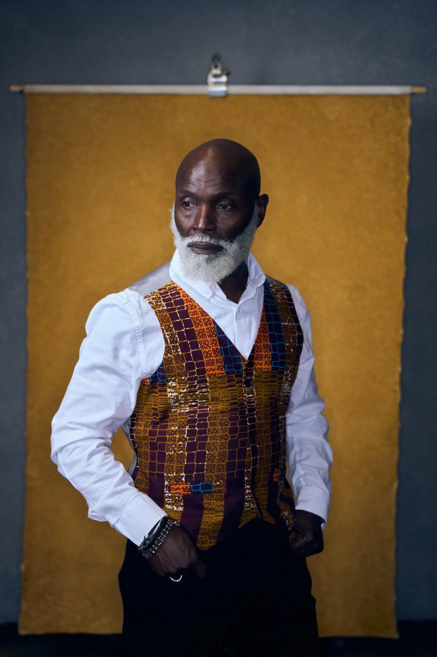 That soft diffused side lighting positioned at about 45 degrees is sculpting this gentleman's features with such controlled elegance - watch how it wraps around his face emphasizing those thoughtful contours while his slightly off-camera gaze adds in