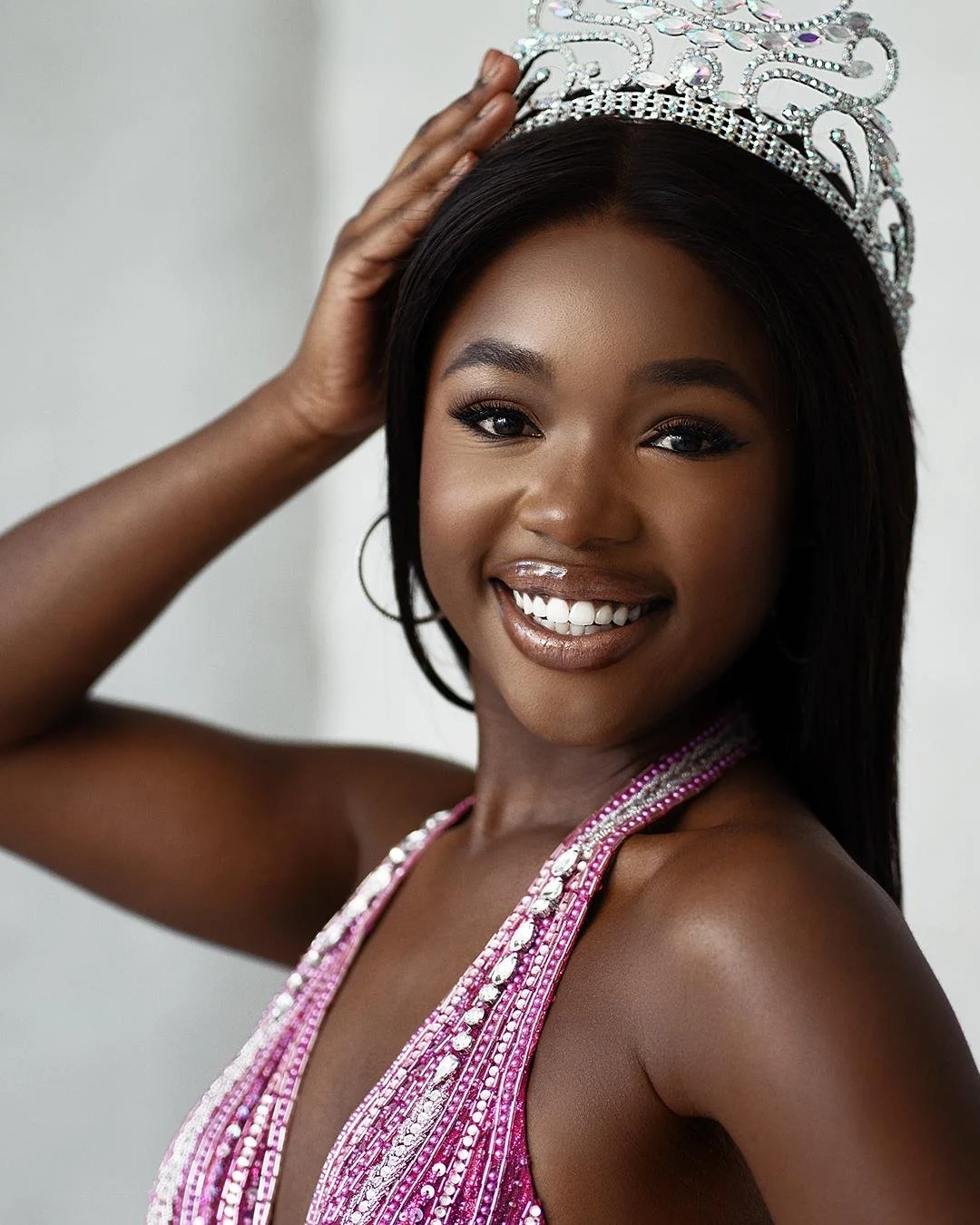 That soft even diffused lighting is doing absolute magic here wrapping around her face and that sparkling pink beaded gown like it was born for this exact moment, creating those buttery highlights that make every sequin shimmer without turning into b