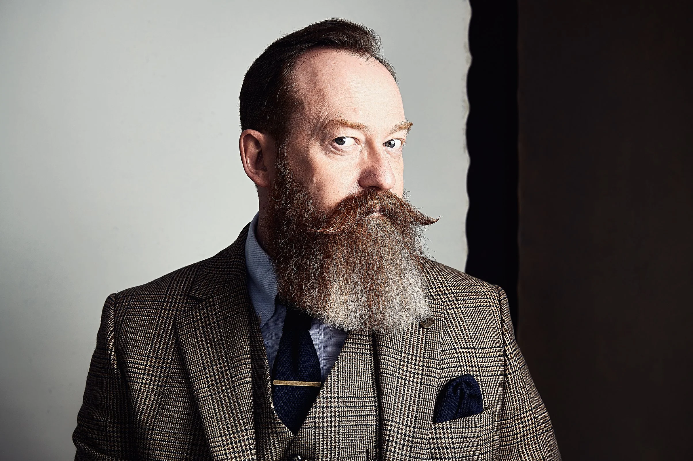Andy Sinclair portrait - bearded man in a tweed suit photographed against a light hand painted canvas backdrop by Hand Painted Backdrops UK.