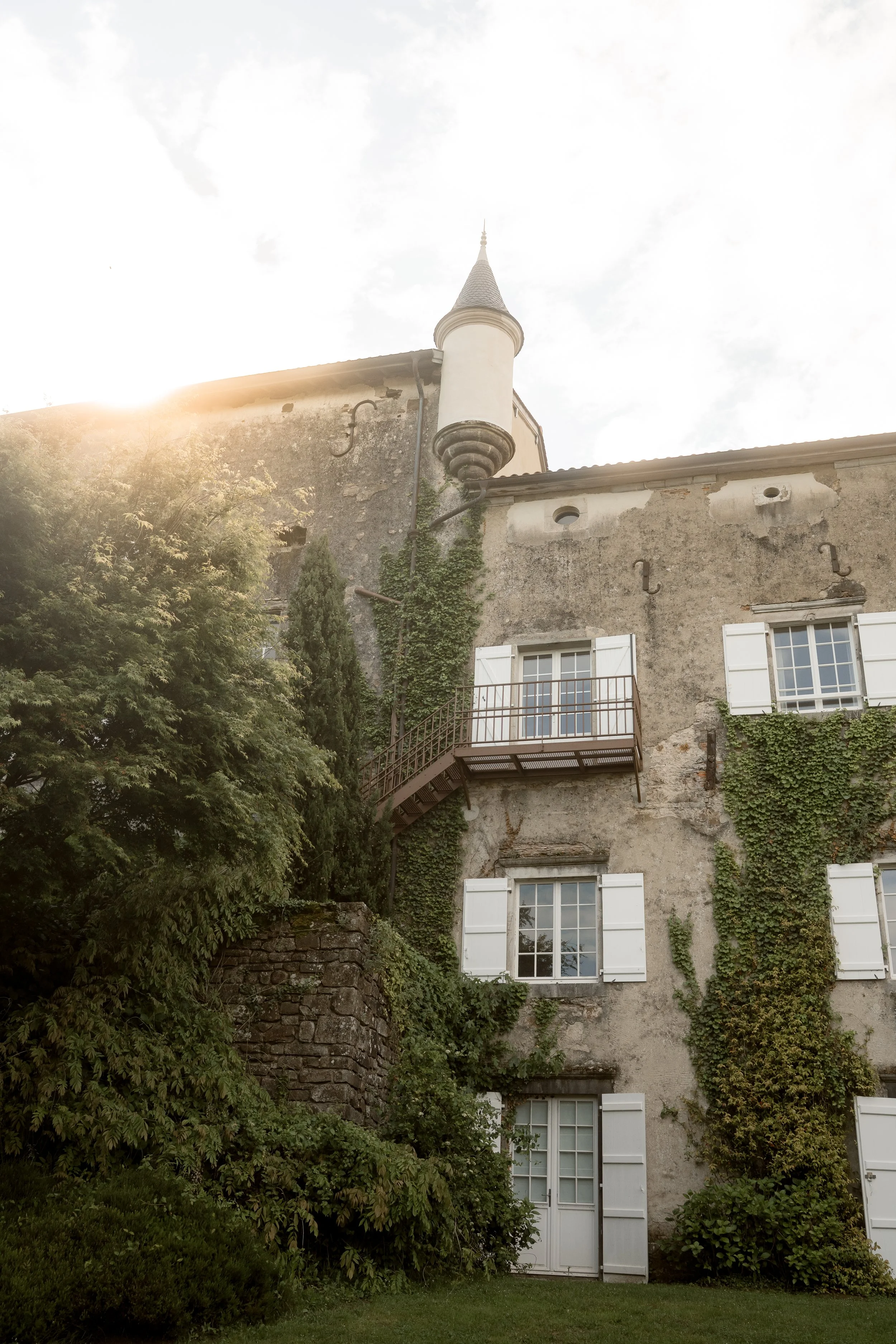 Vue aérienne d'un manoir avec piscine entouré de collines verdoyantes, arbres et pelouses, parfait pour un événement en plein air.