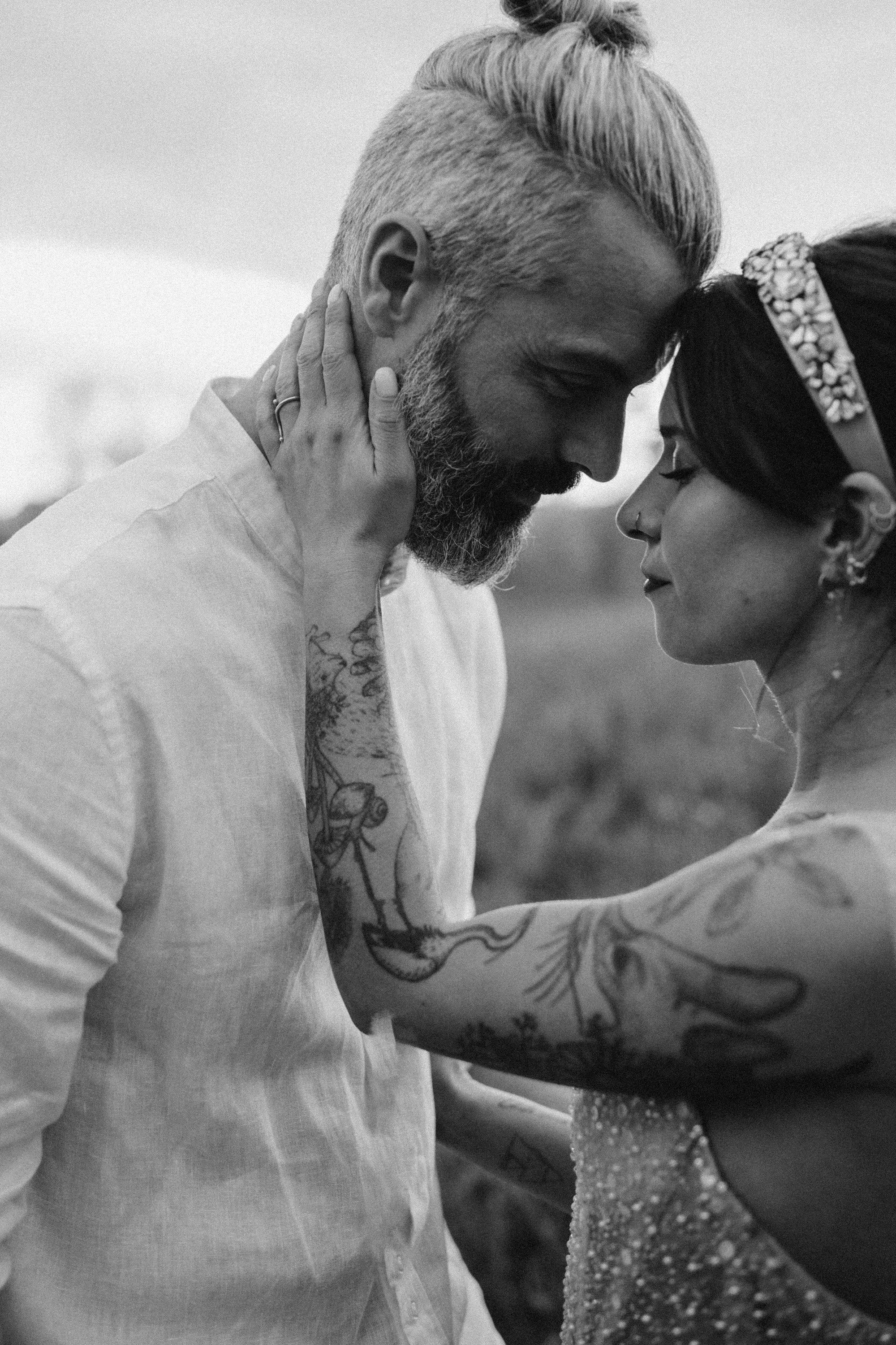 Un couple regarde tendrement, tête contre tête, lors d'une séance photo en noir et blanc, symbolisant l’amour et la connexion