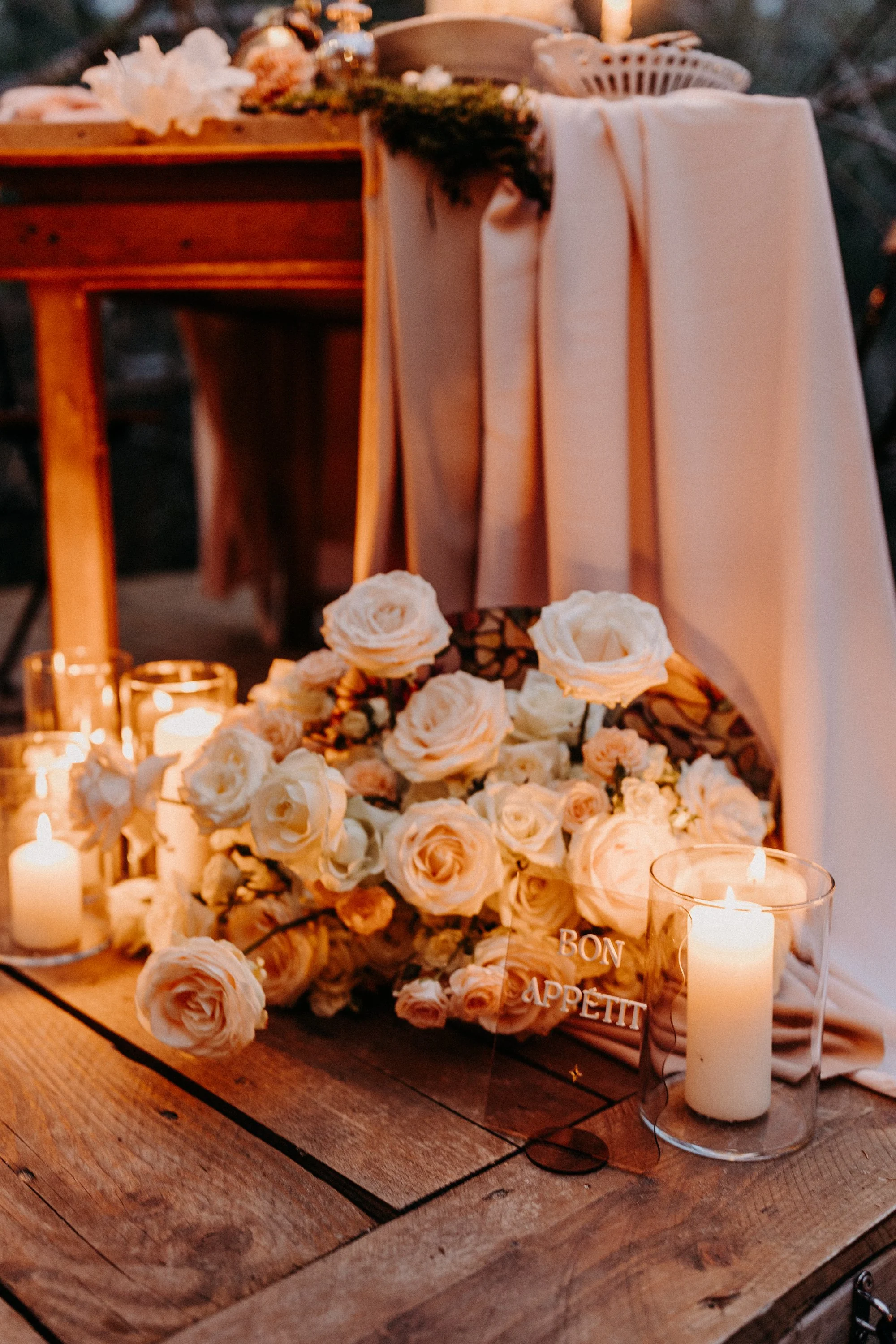 Arrangement de fleurs blanches sur une table en bois avec des bougies allumées, décoration chaleureuse et romantique