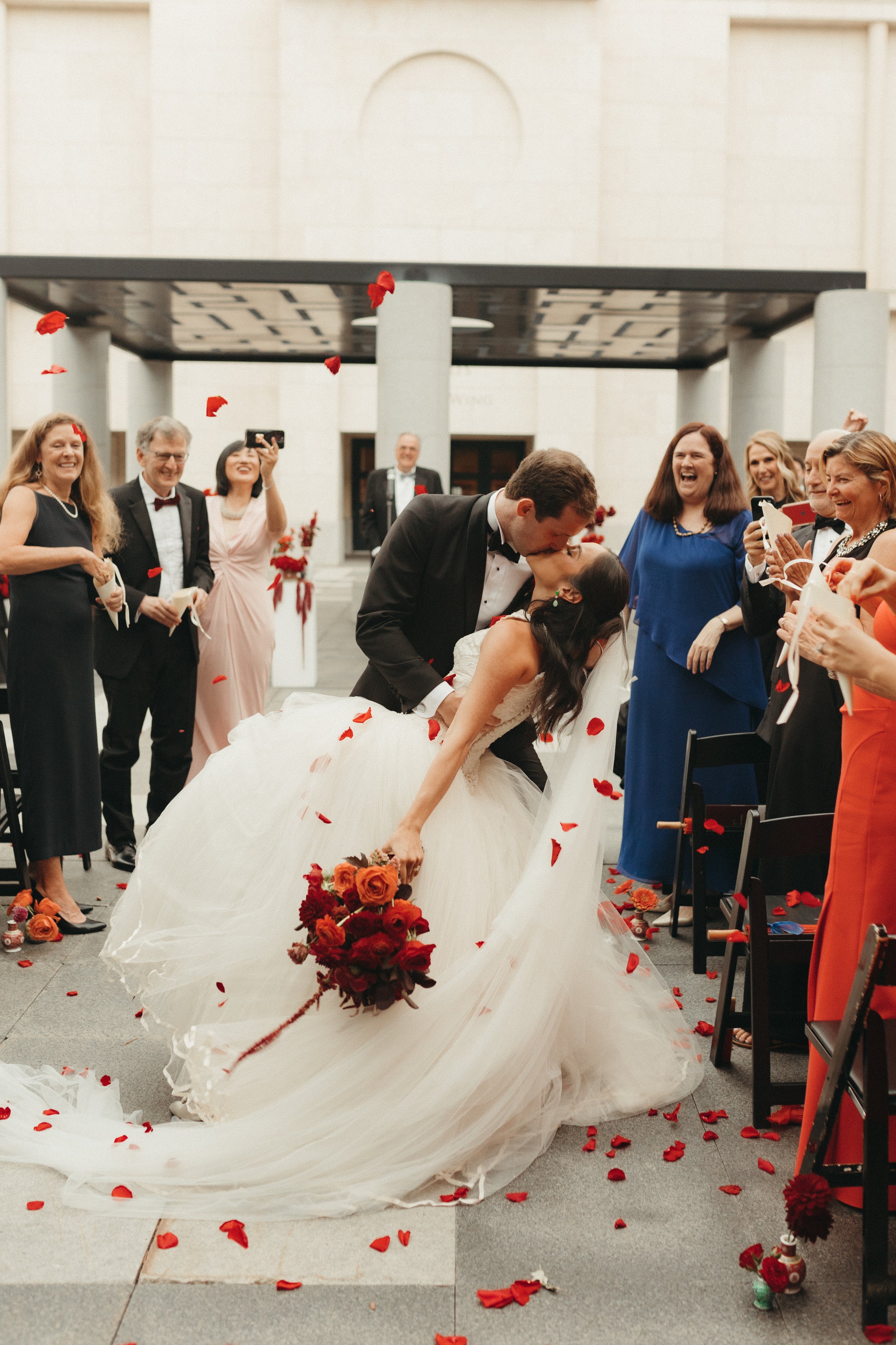 newlyweds aisle dip & kiss, red flower wedding at Minneapolis Institute of Art in MN