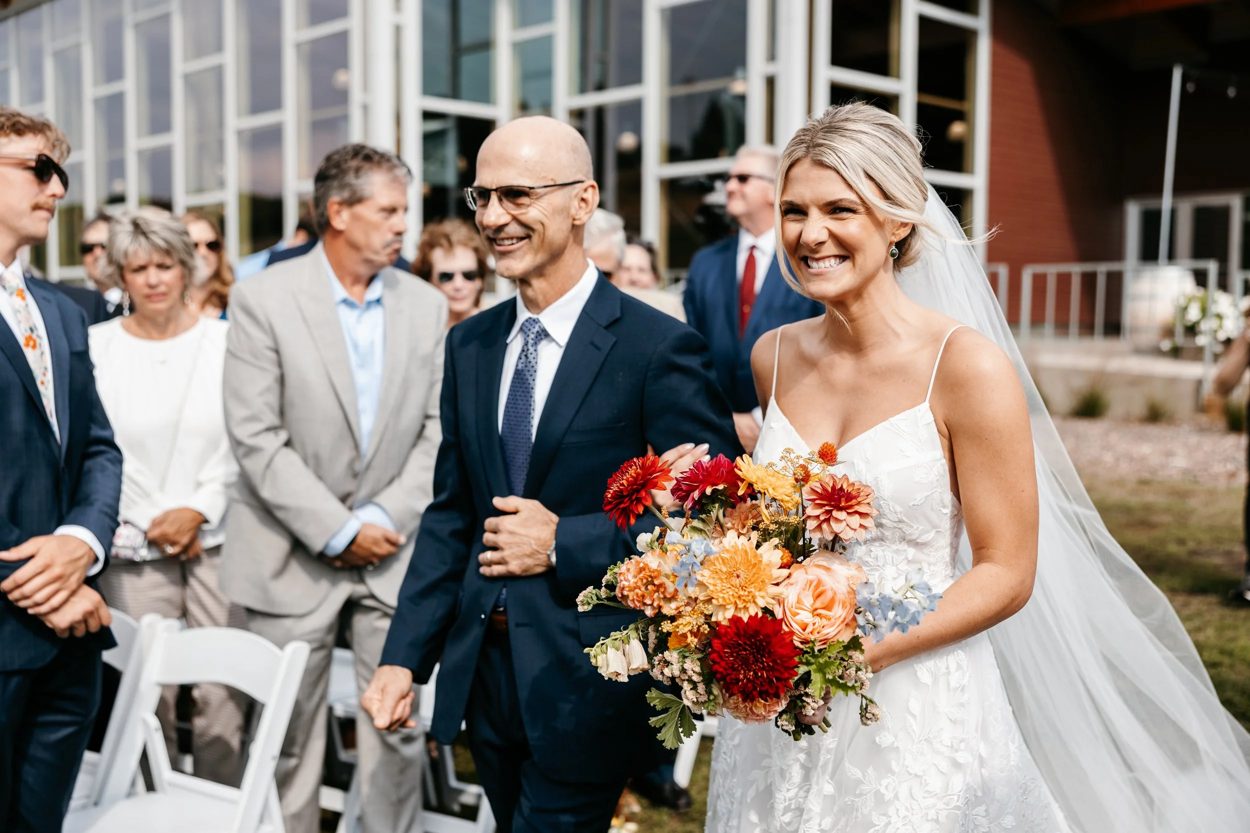 bride + father of the bride walking down the aisle with a burgundy, peach, and blue bridal bouquet, Hyland Hills Chalet wedding in Bloomington MN
