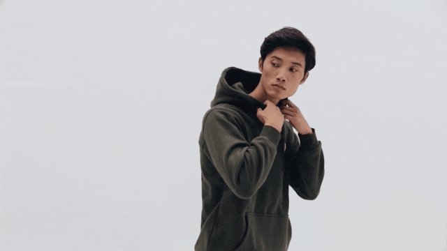 Person wearing a green hoodie on a neutral background.