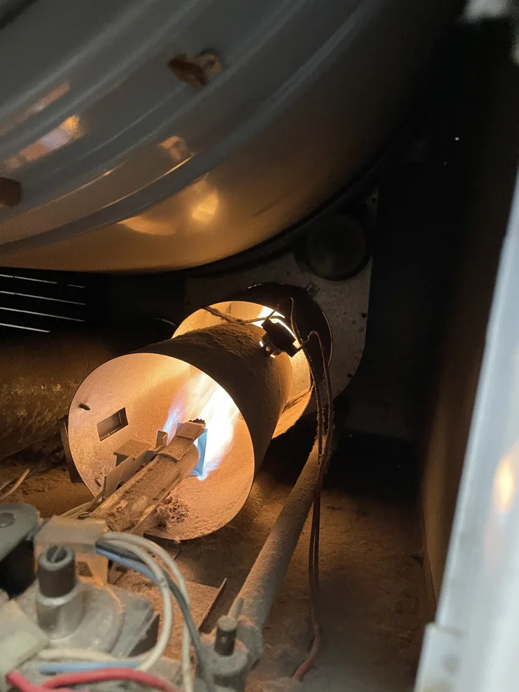 A burner glowing orange inside a furnace