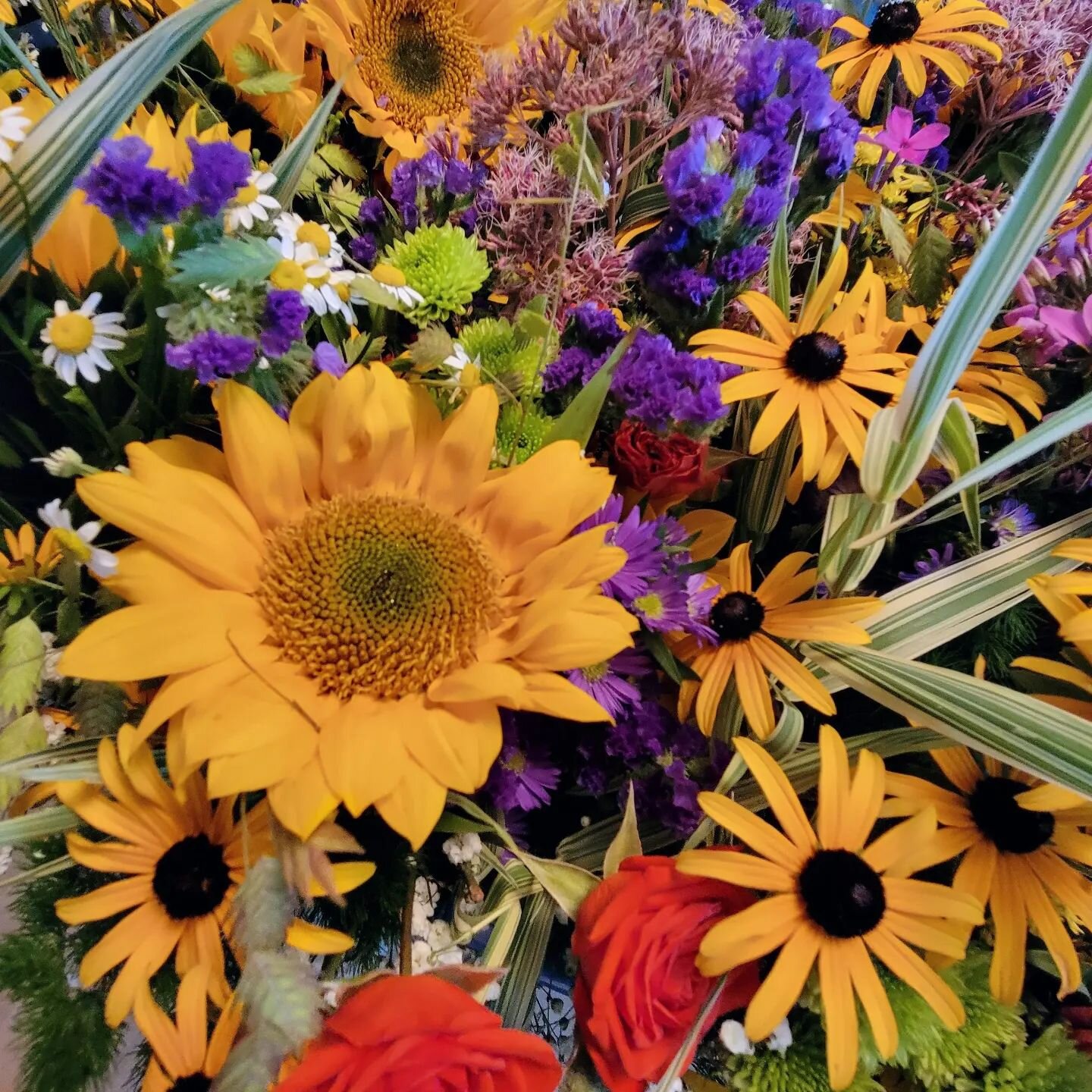 Centerpieces for celebrating the life of a special friend's mama. She wanted &quot;Iowa farm flowers&quot;. I used a mix of sunflowers, chamomile, ornamental grasses, black-eyed Susan, asters, chamomile, Joe-pye, roses and a little bit of this and th