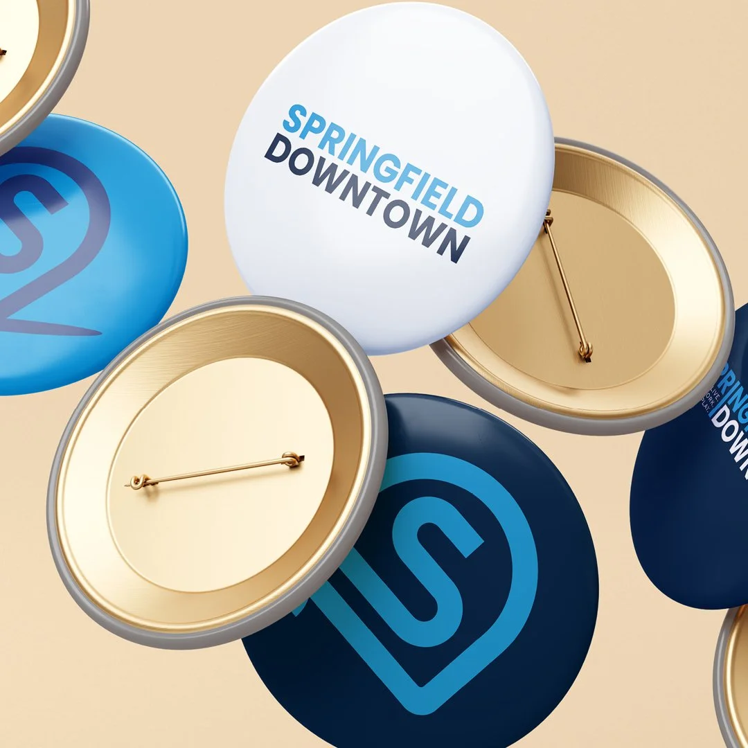 metal logo pins floating on cream background