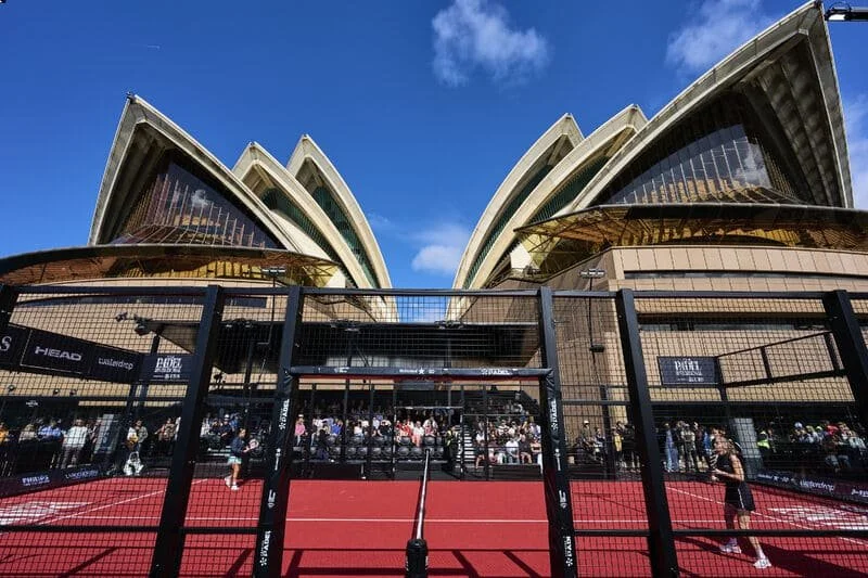 Spectators watching a padel match at the Padel Invitational, with Sydney Harbour in the background